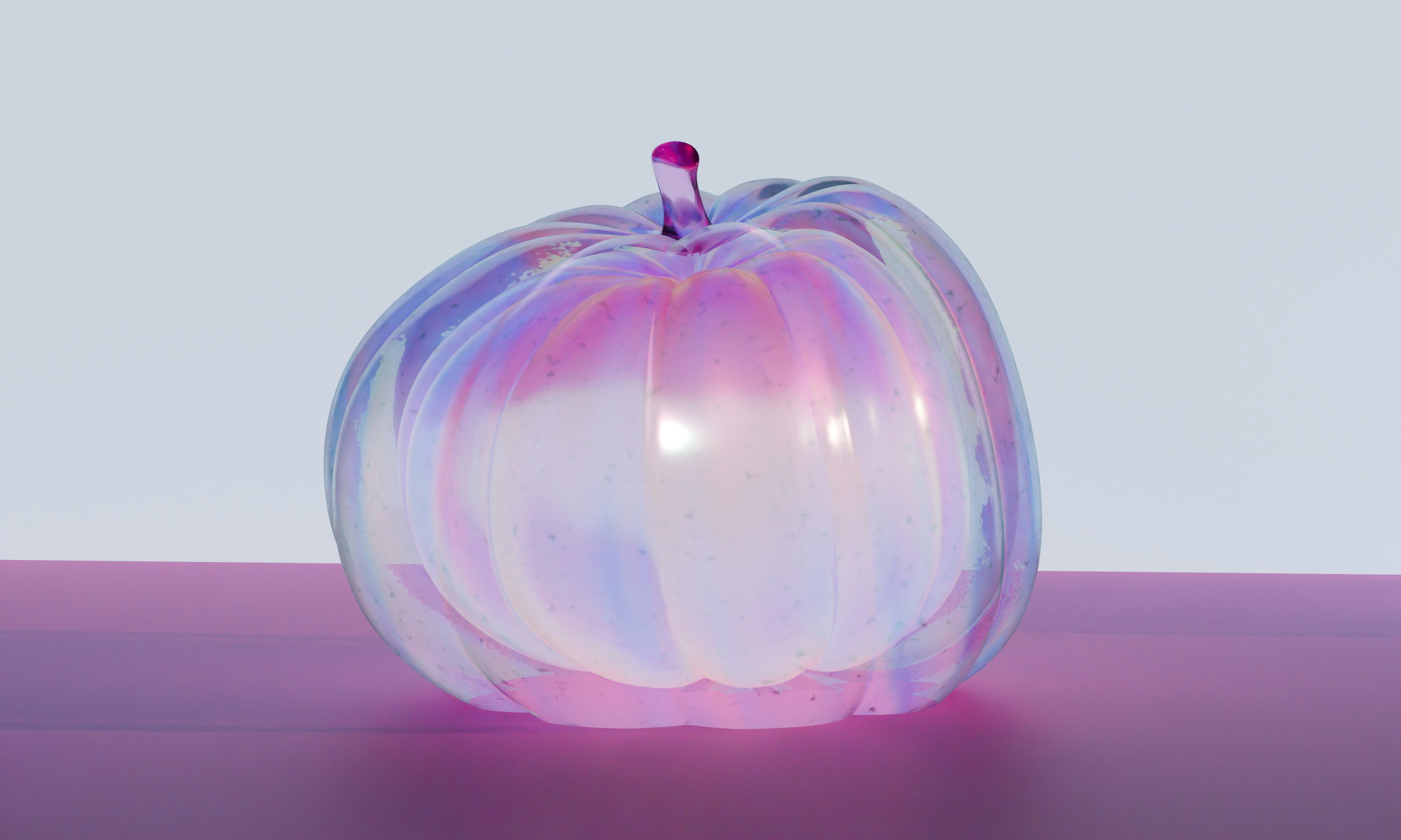 Ein irisierender Glaskürbis auf einer violetten Oberfläche vor hellem Hintergrund