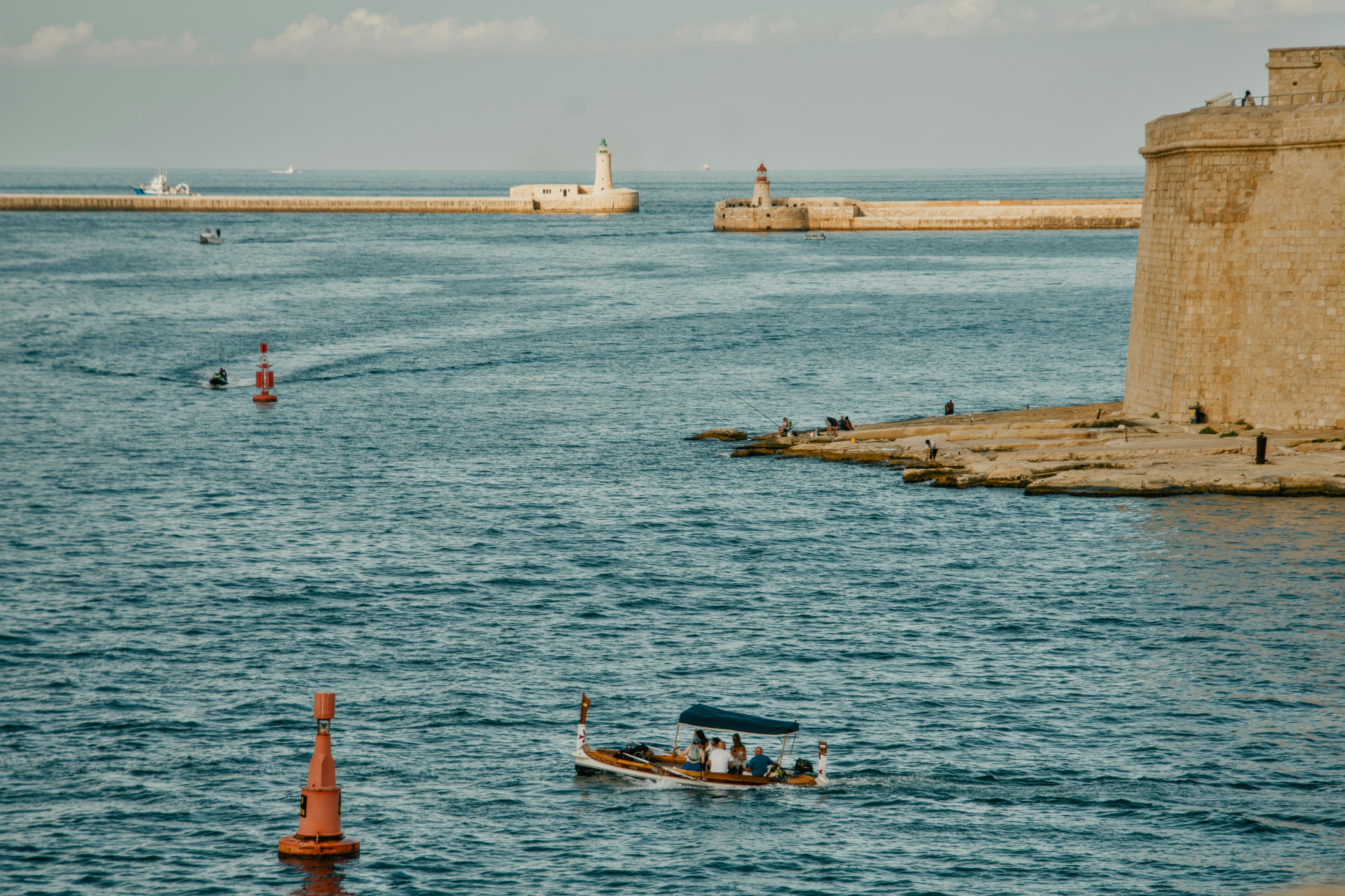 A traditional dghajsa boat carrying passengers across the Grand Harbour in Valletta, Malta