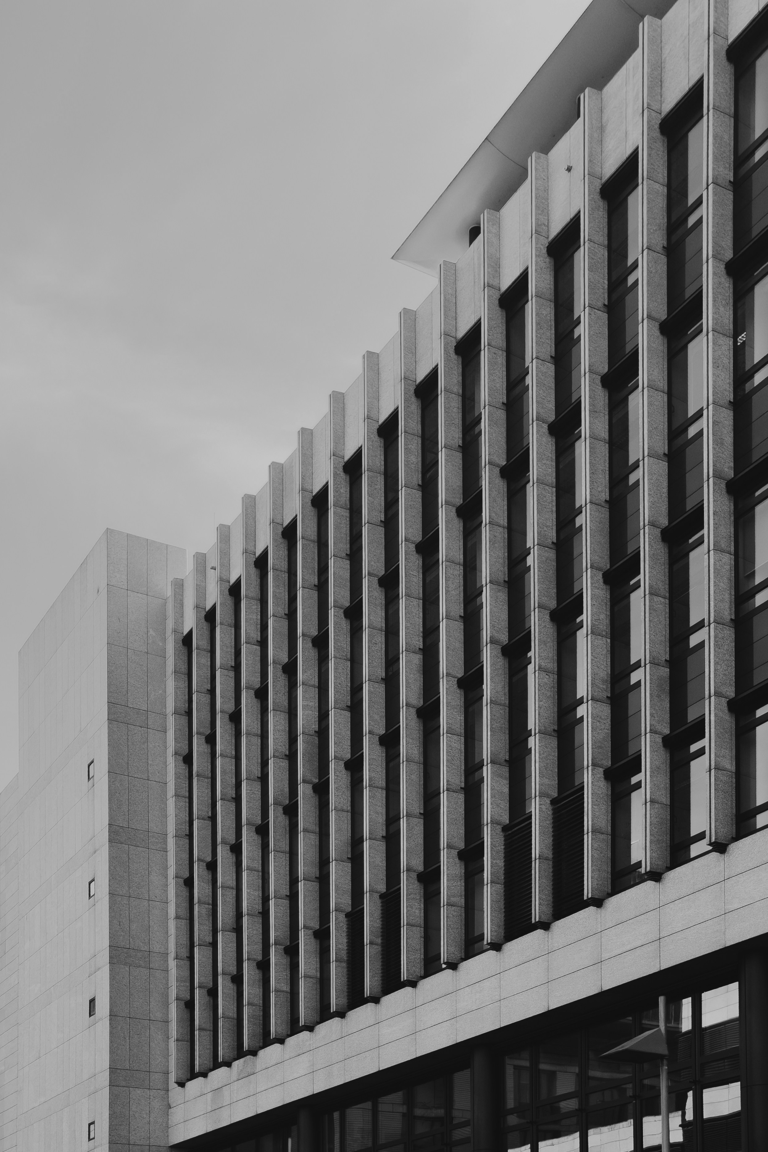 Ein modernes Bürogebäude mit einem Raster aus vertikalen Steinflossen und Fenstern