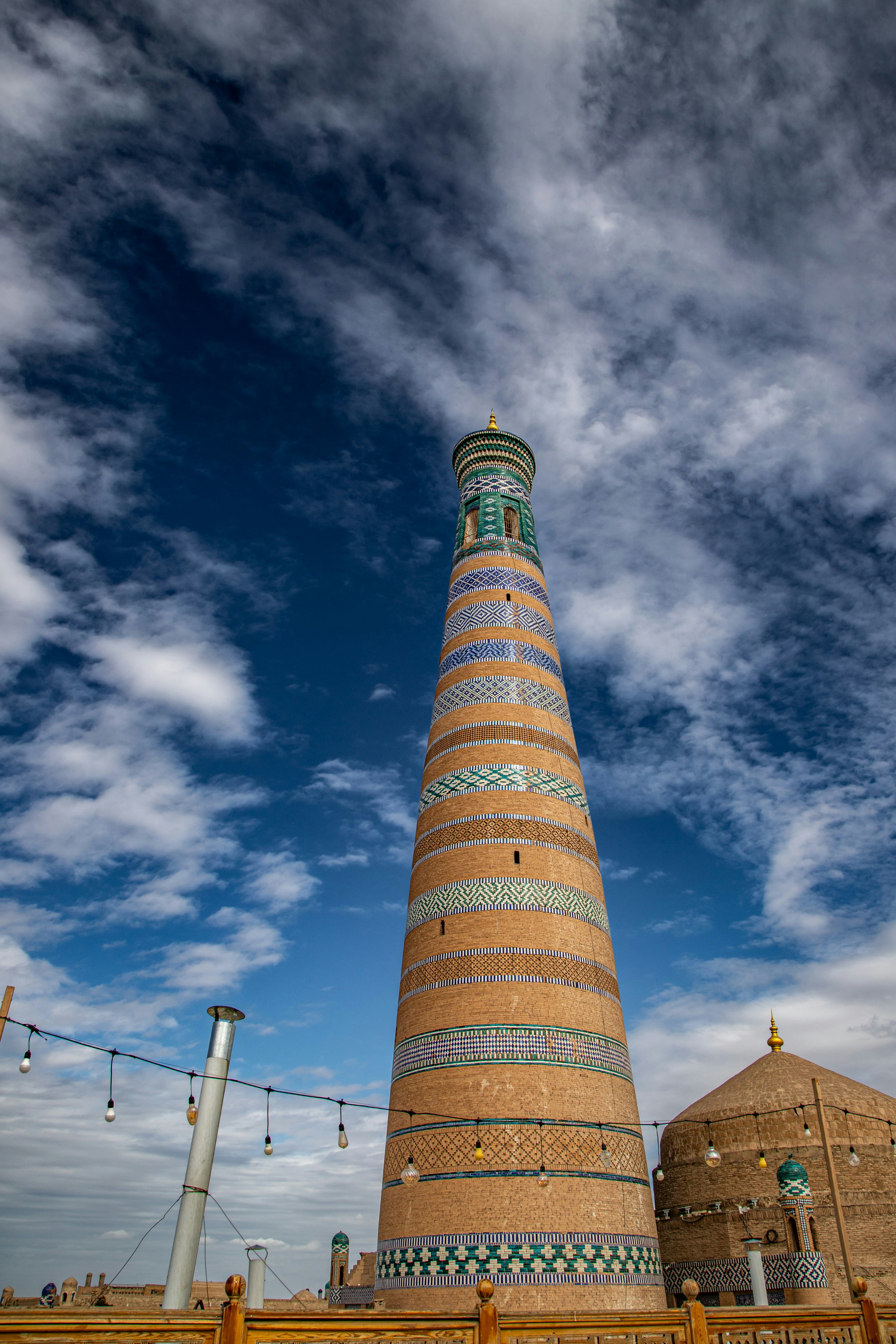 O minarete Islam Khoja com padrões de azulejos azuis e brancos contra um céu nublado
