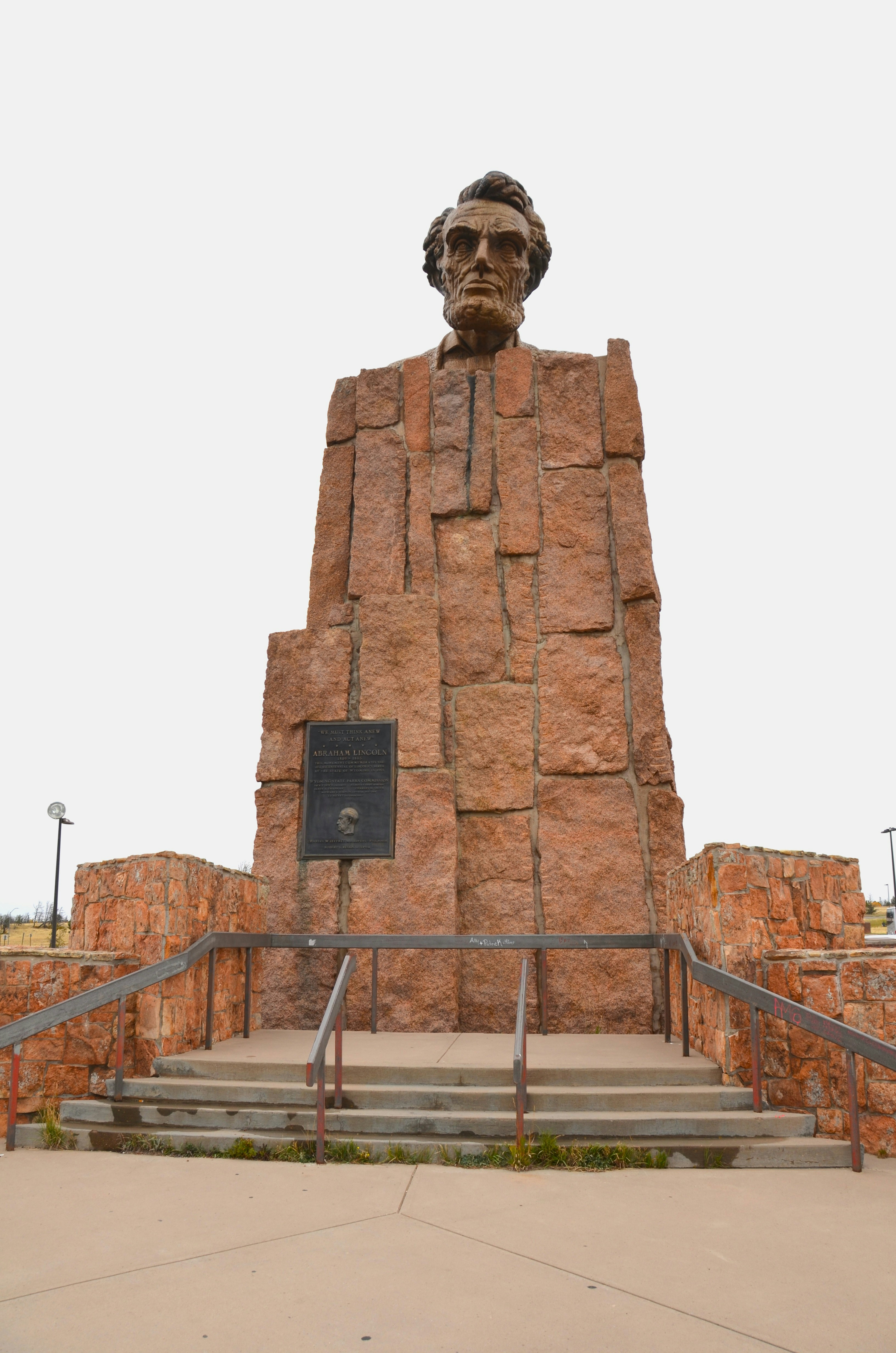 A large stone bust of Abraham Lincoln atop a tall rectangular granite monument