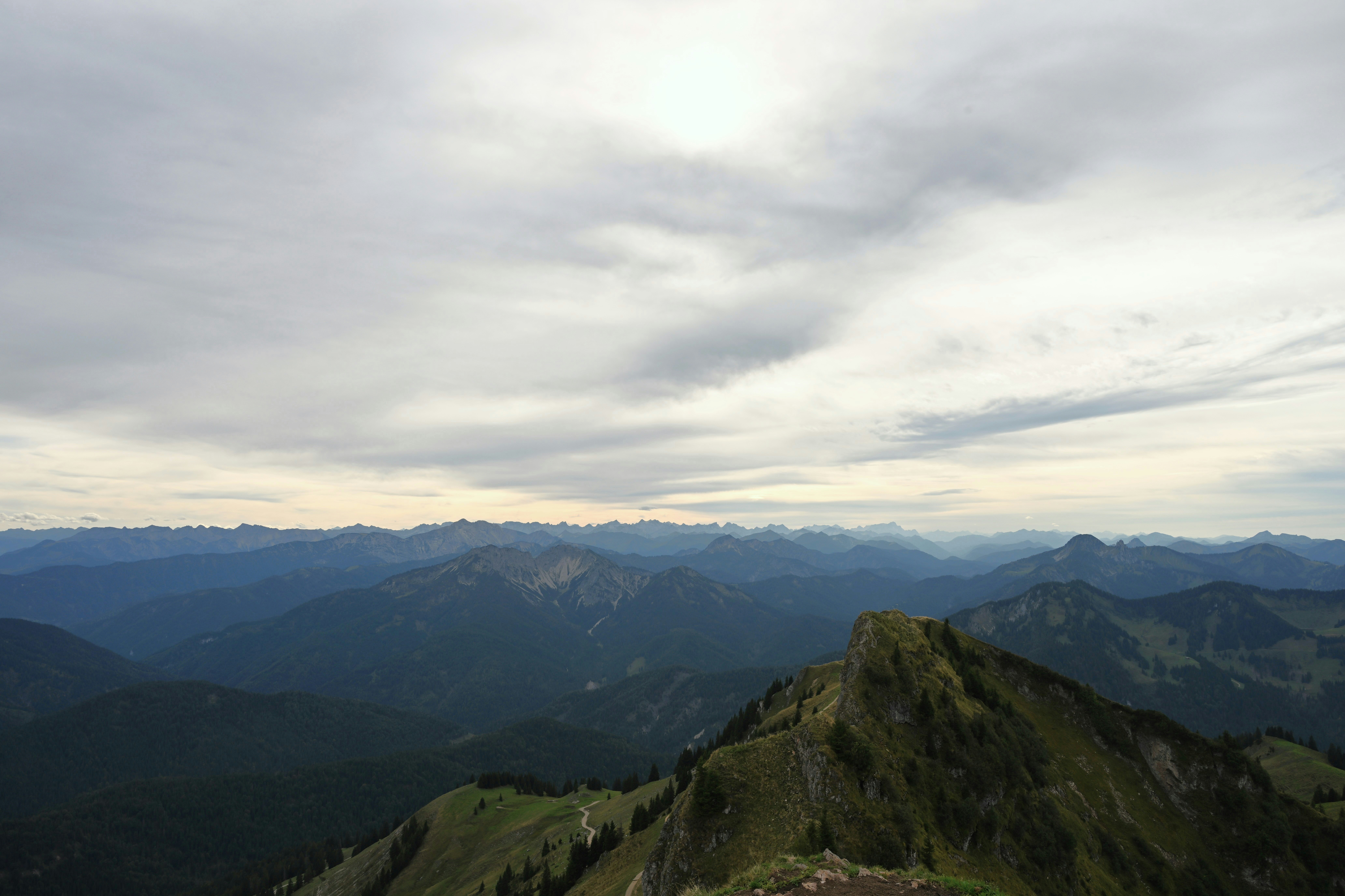 A mountain ridge with green slopes under a vast cloudy sky