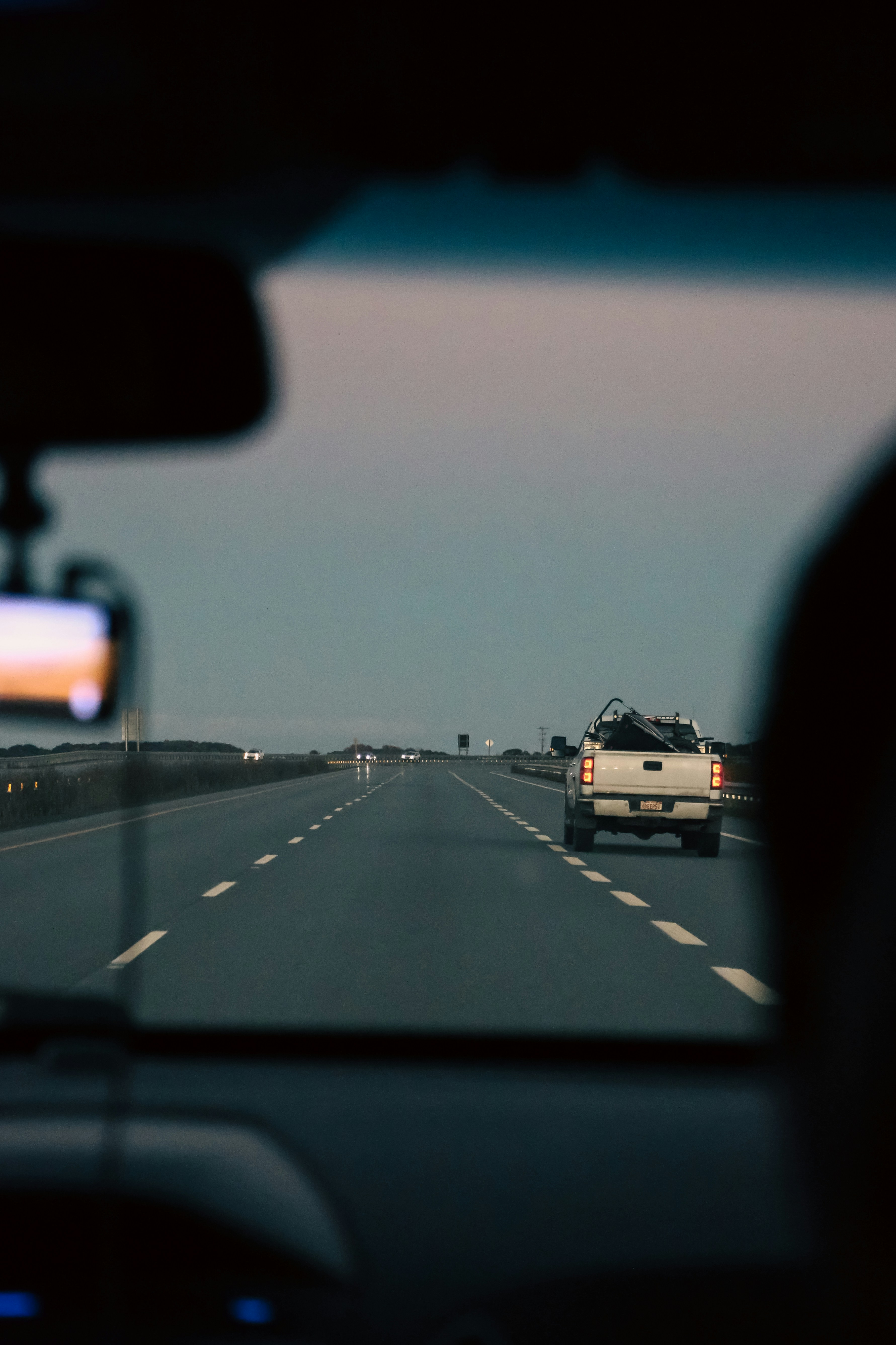Un pick-up blanc roulant sur une autoroute au crépuscule