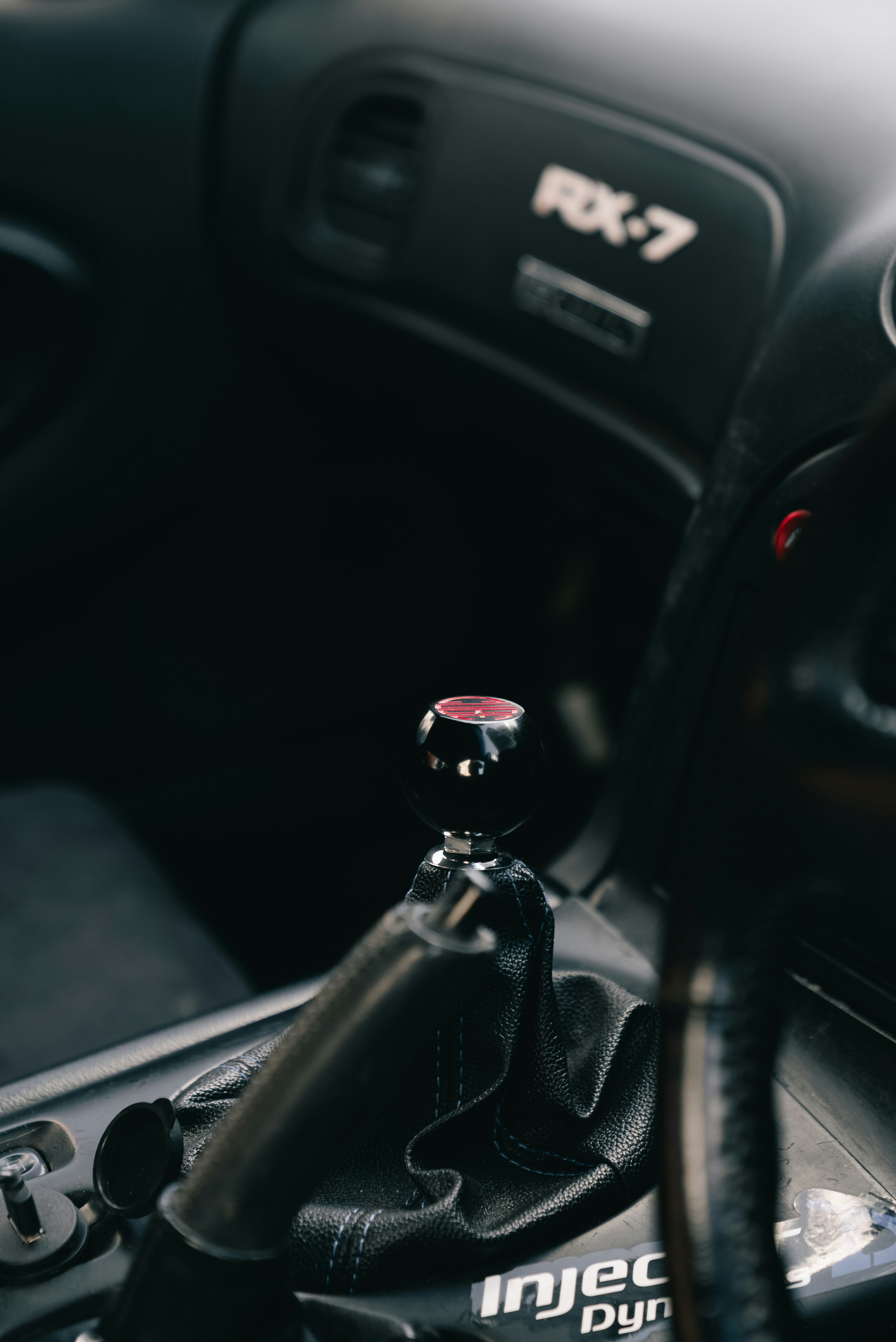 Un pomo de palanca de cambios esférico negro en el interior de un RX-7