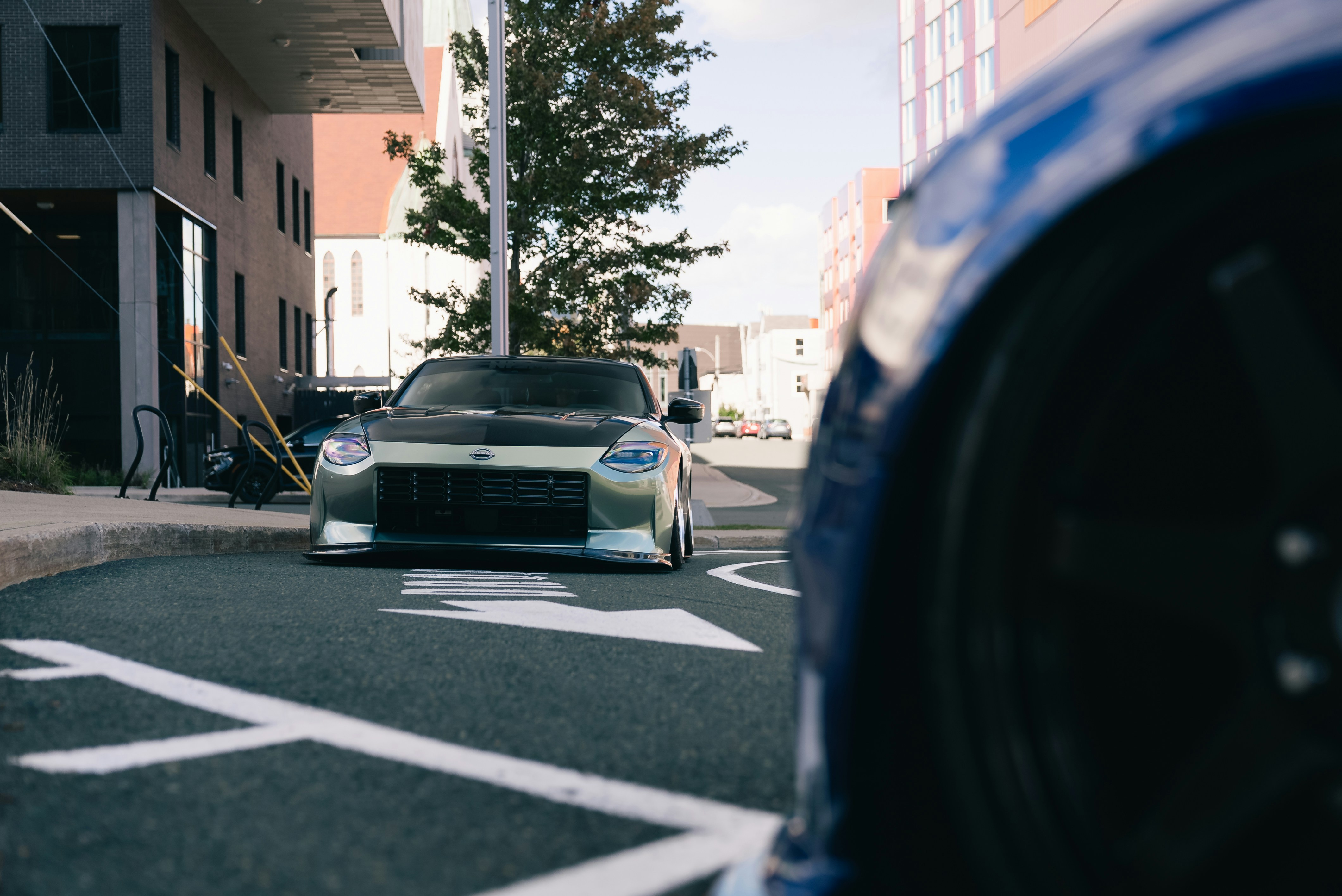 Un Nissan Z deportivo verde aparcado en una calle asfaltada en una ciudad