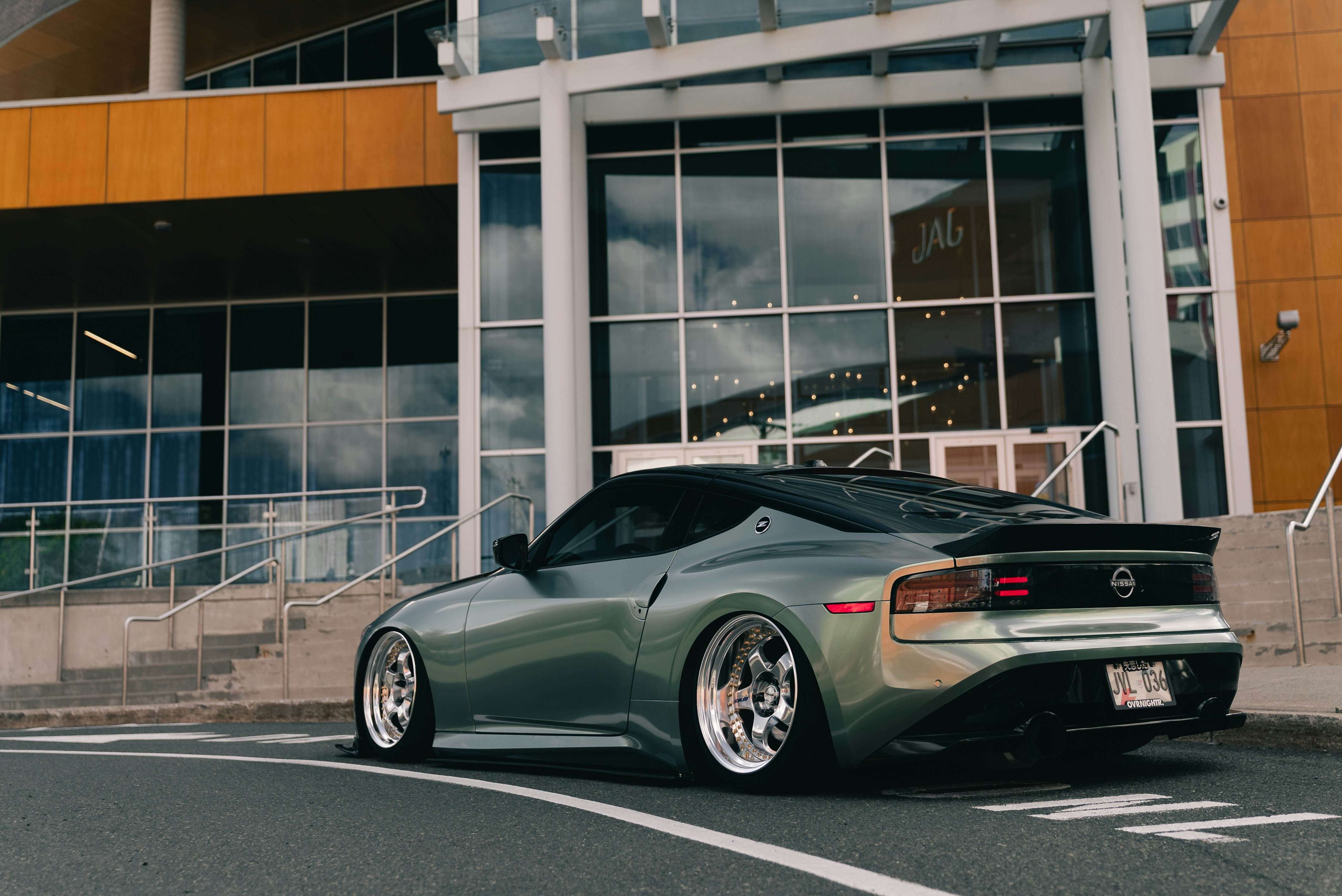Un Nissan Z deportivo verde modificado aparcado en una calle asfaltada