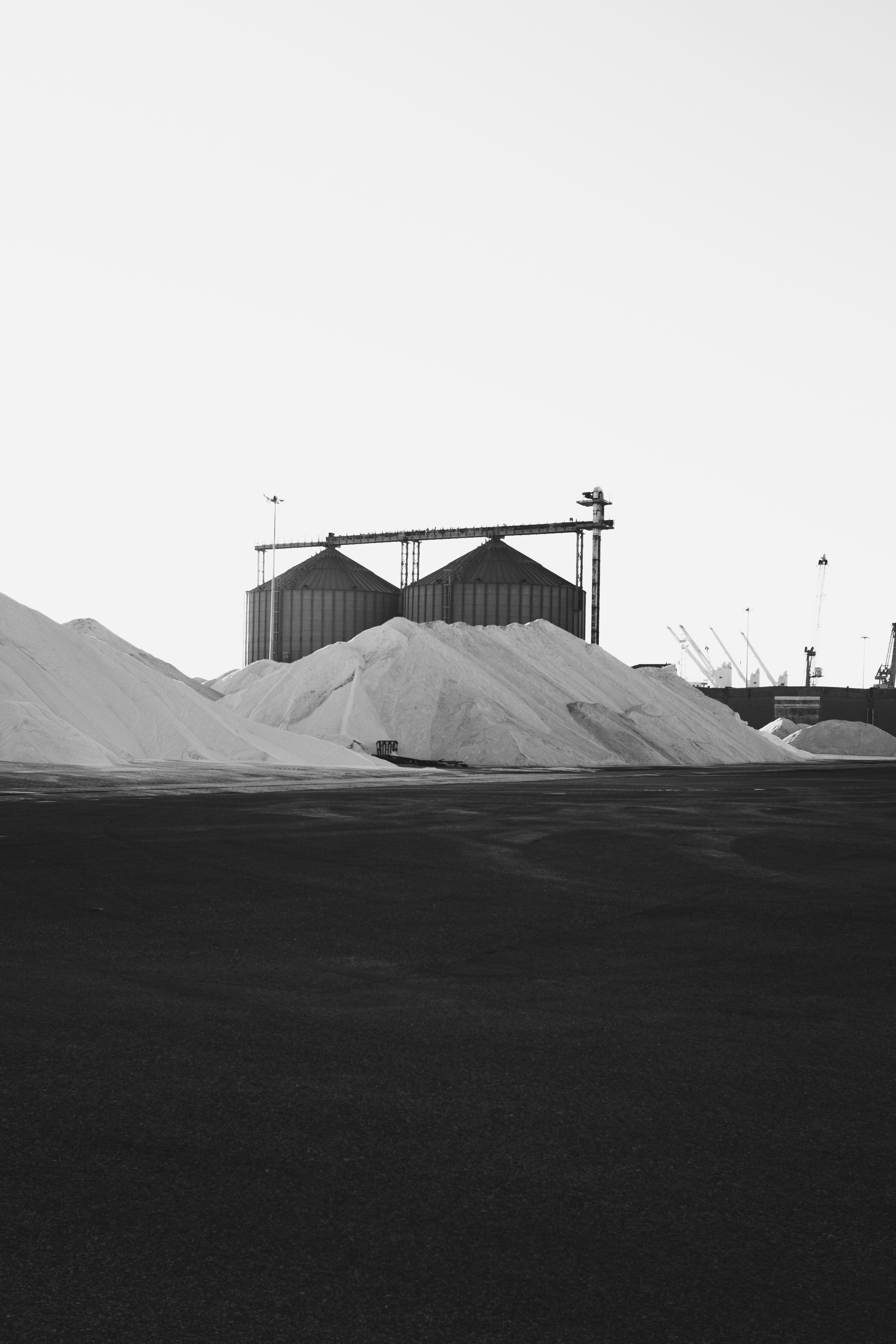 Grandes pilhas de sal branco ao lado de silos industriais em Aveiro, Portugal