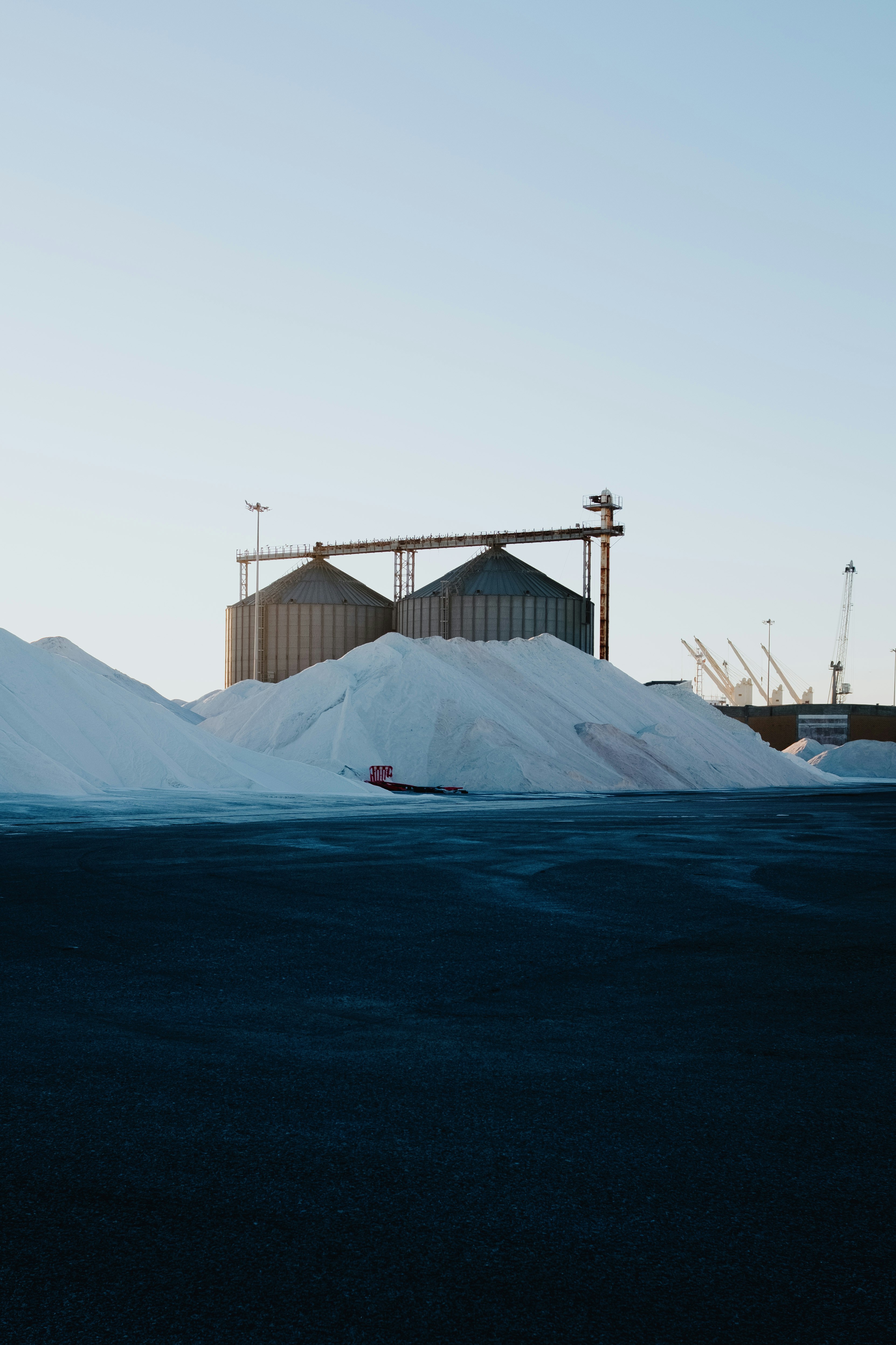 Grandes pilhas de sal branco ao lado de silos industriais em Aveiro, Portugal