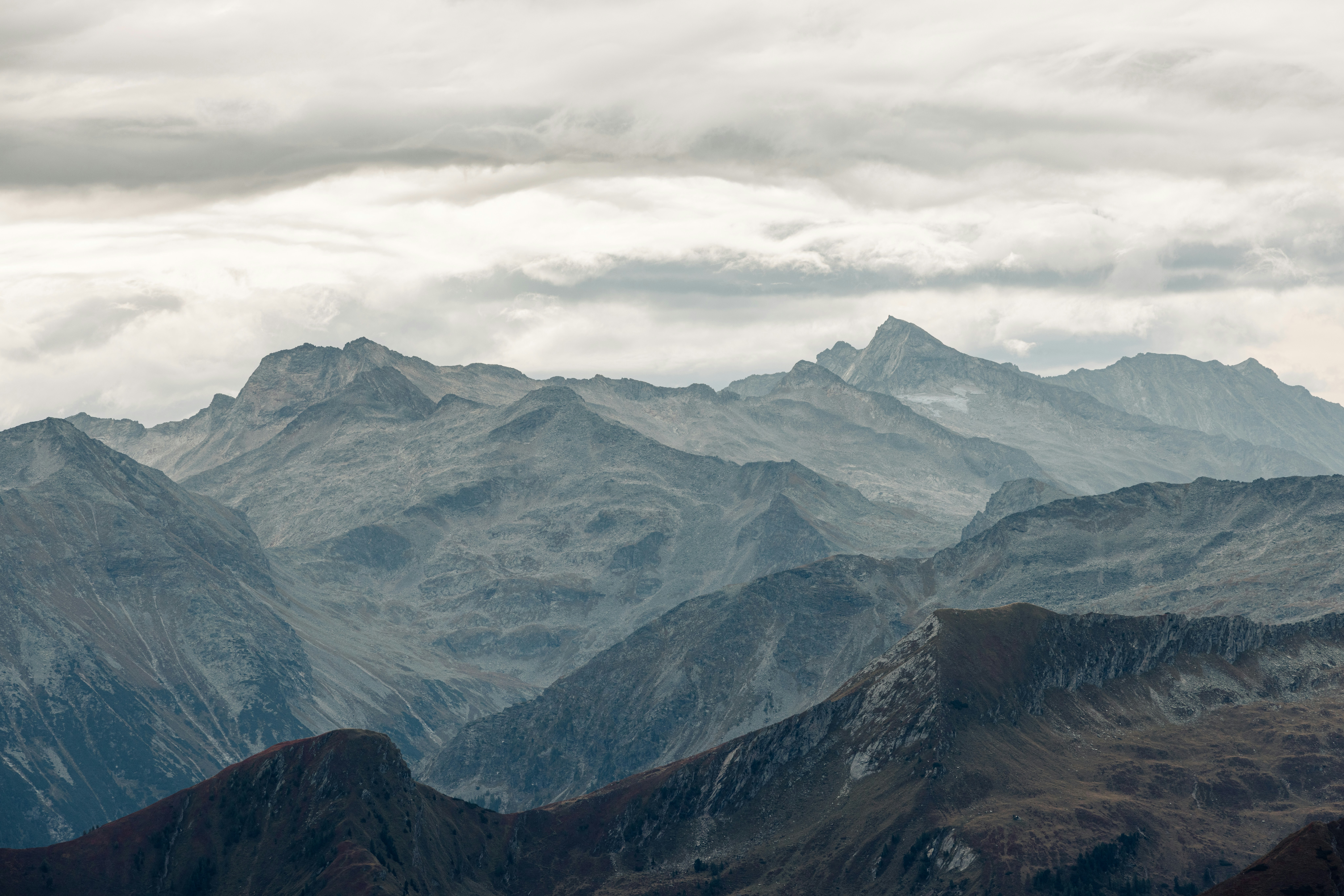 Cime rocciose stratificate sotto un cielo denso e coperto