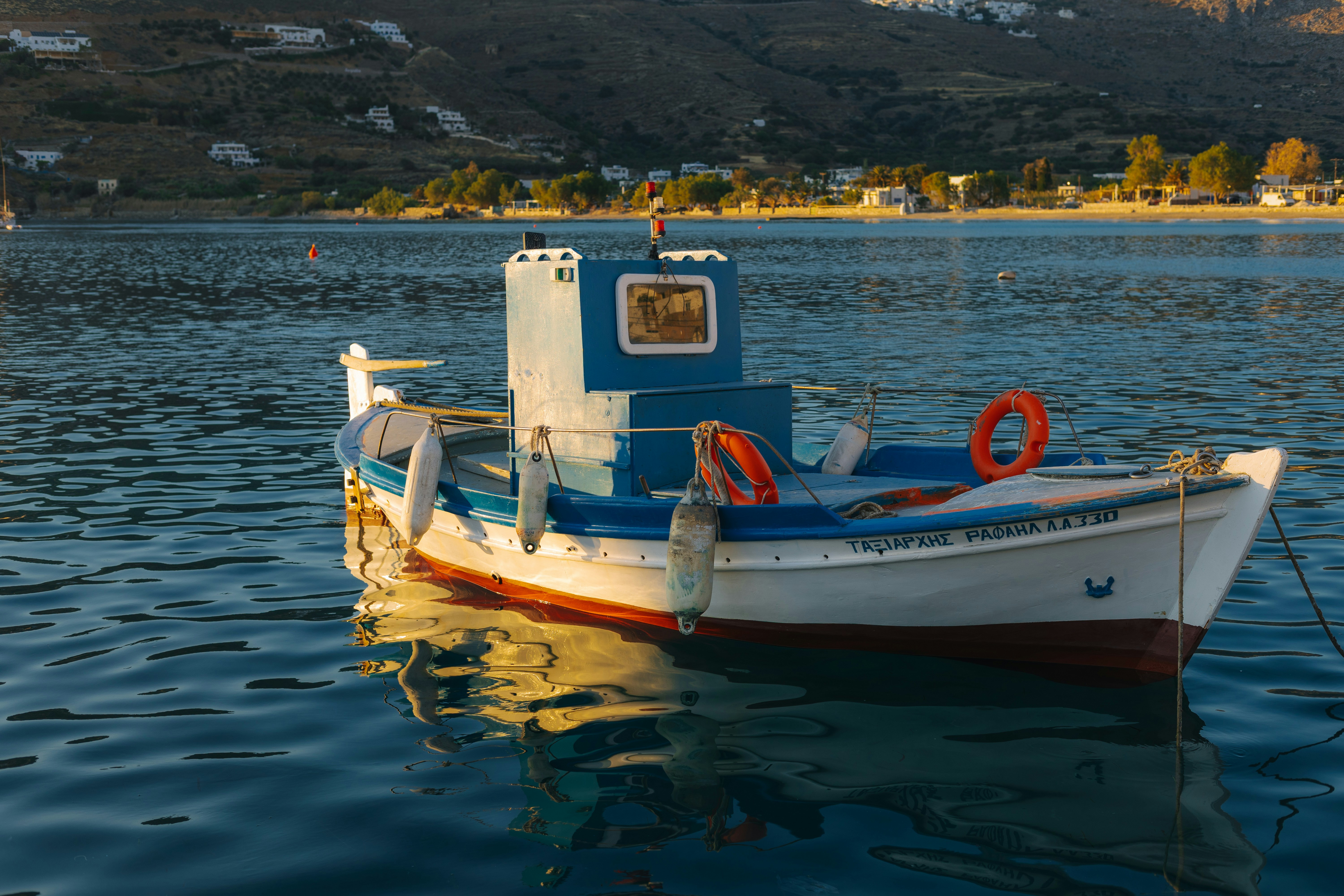 Fishing boat on calm water - Free Photo on Unsplash