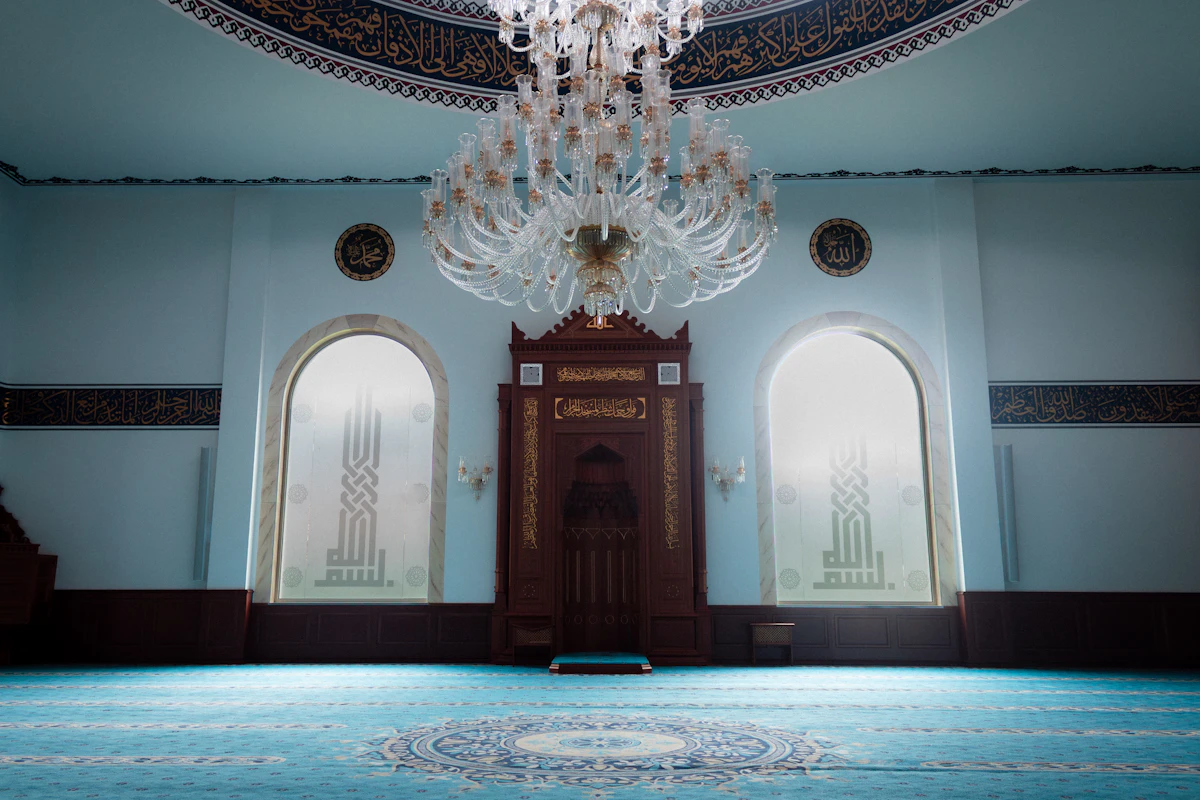 Lampu gantung kristal besar di dalam masjid berkarpet biru