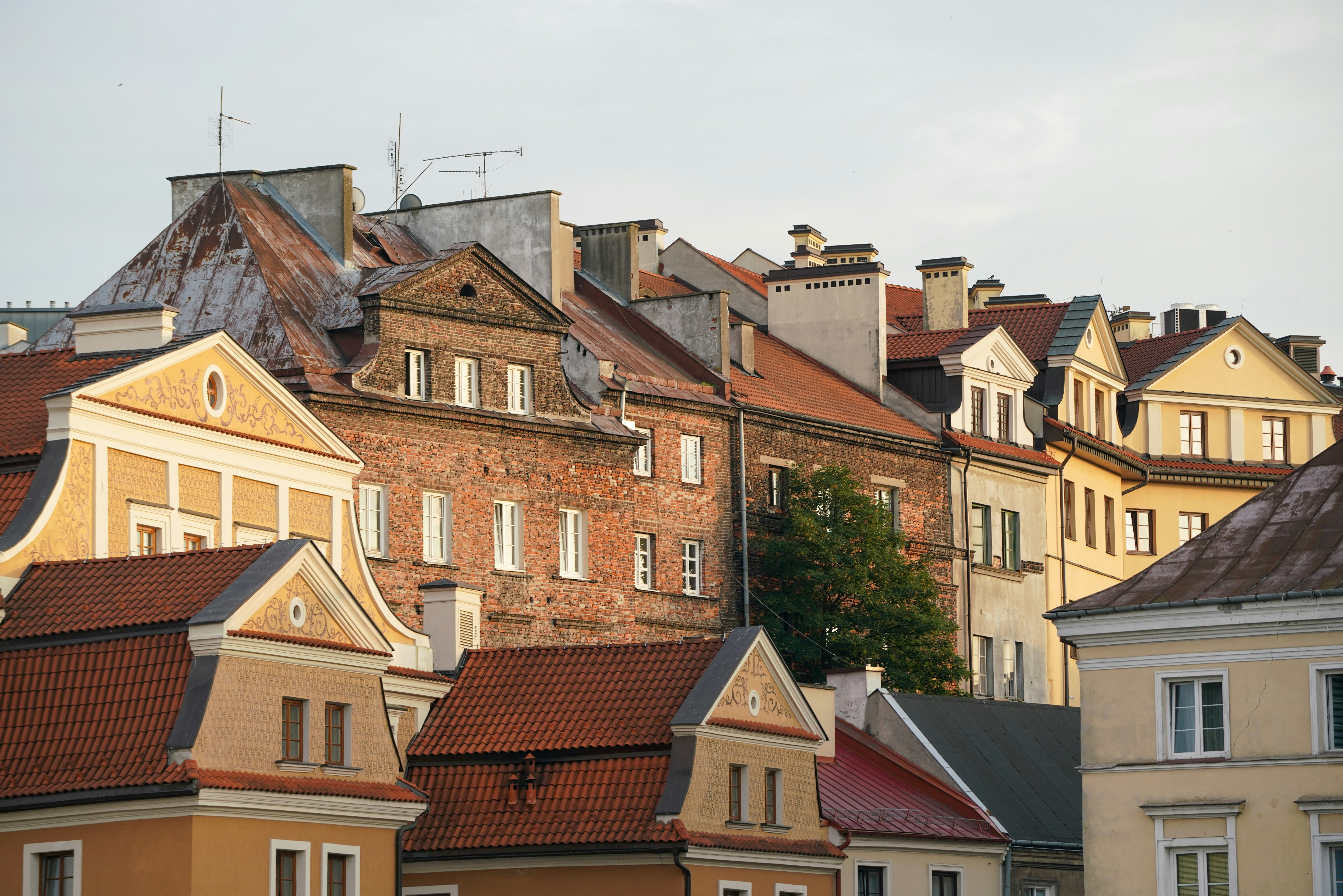 Historic brick and stucco buildings with red tile roofs in Warsaw
