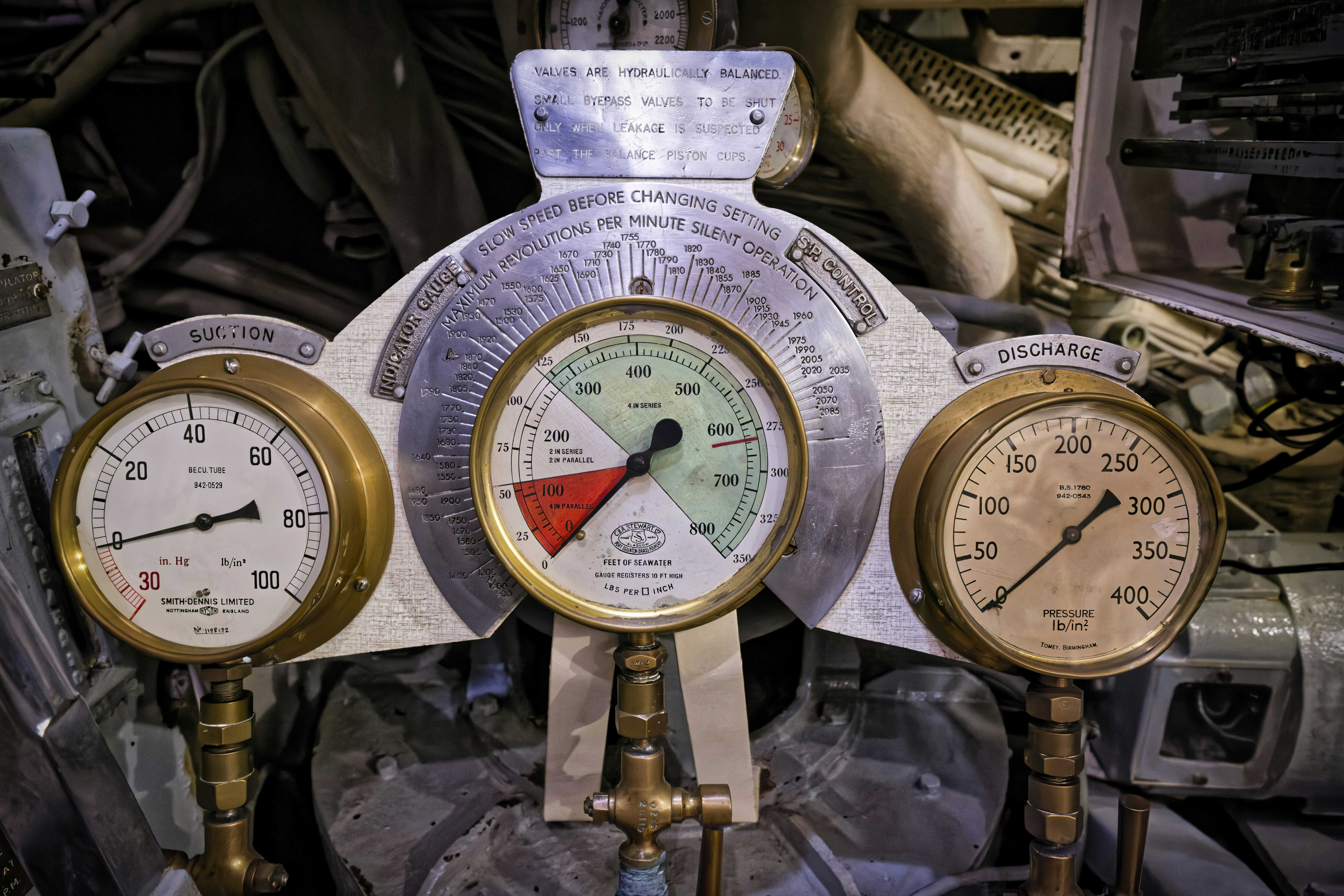 Three brass pressure gauges on industrial piping