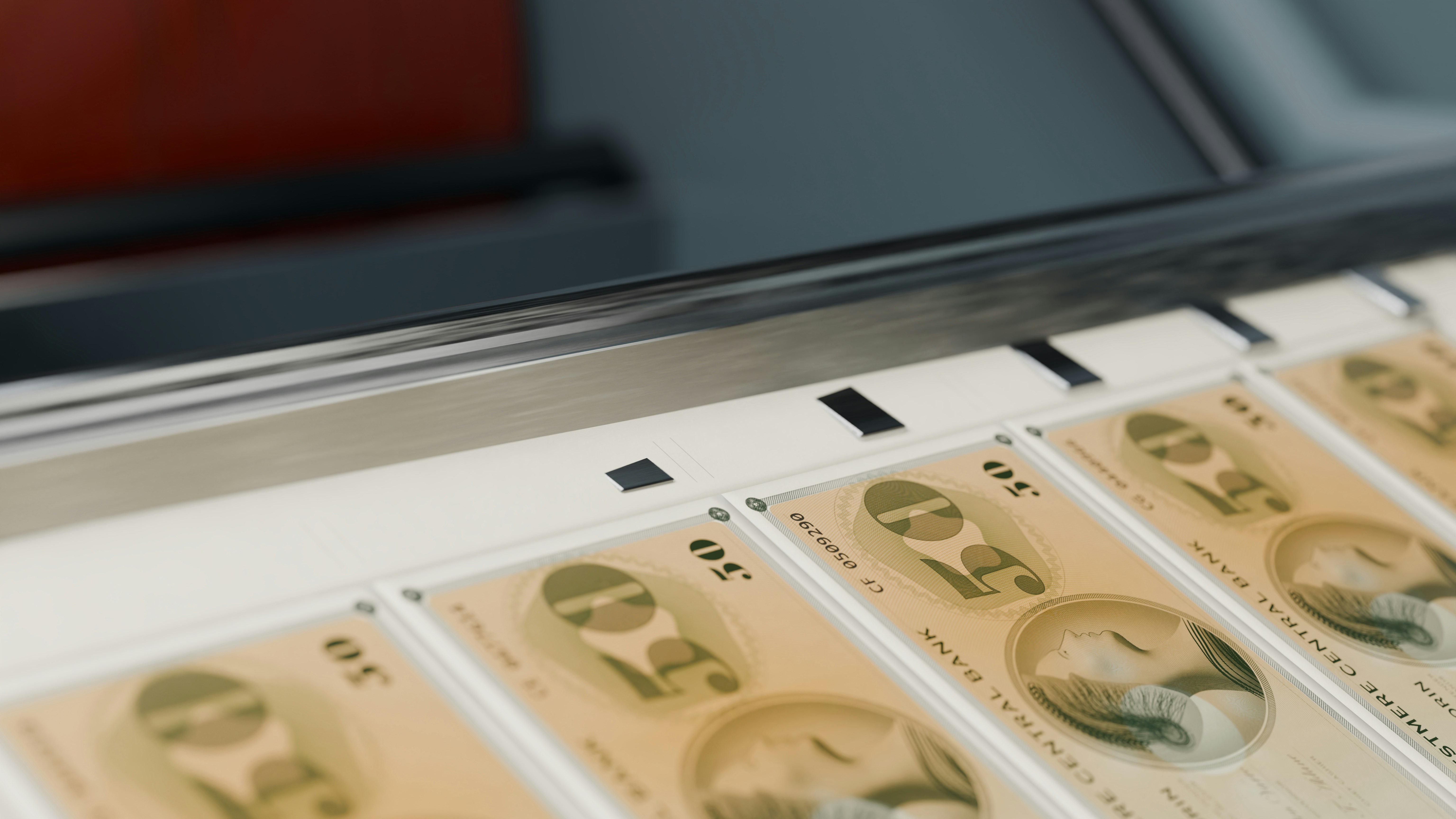 Fifty denomination banknotes moving along a metal conveyor belt in a printing facility
