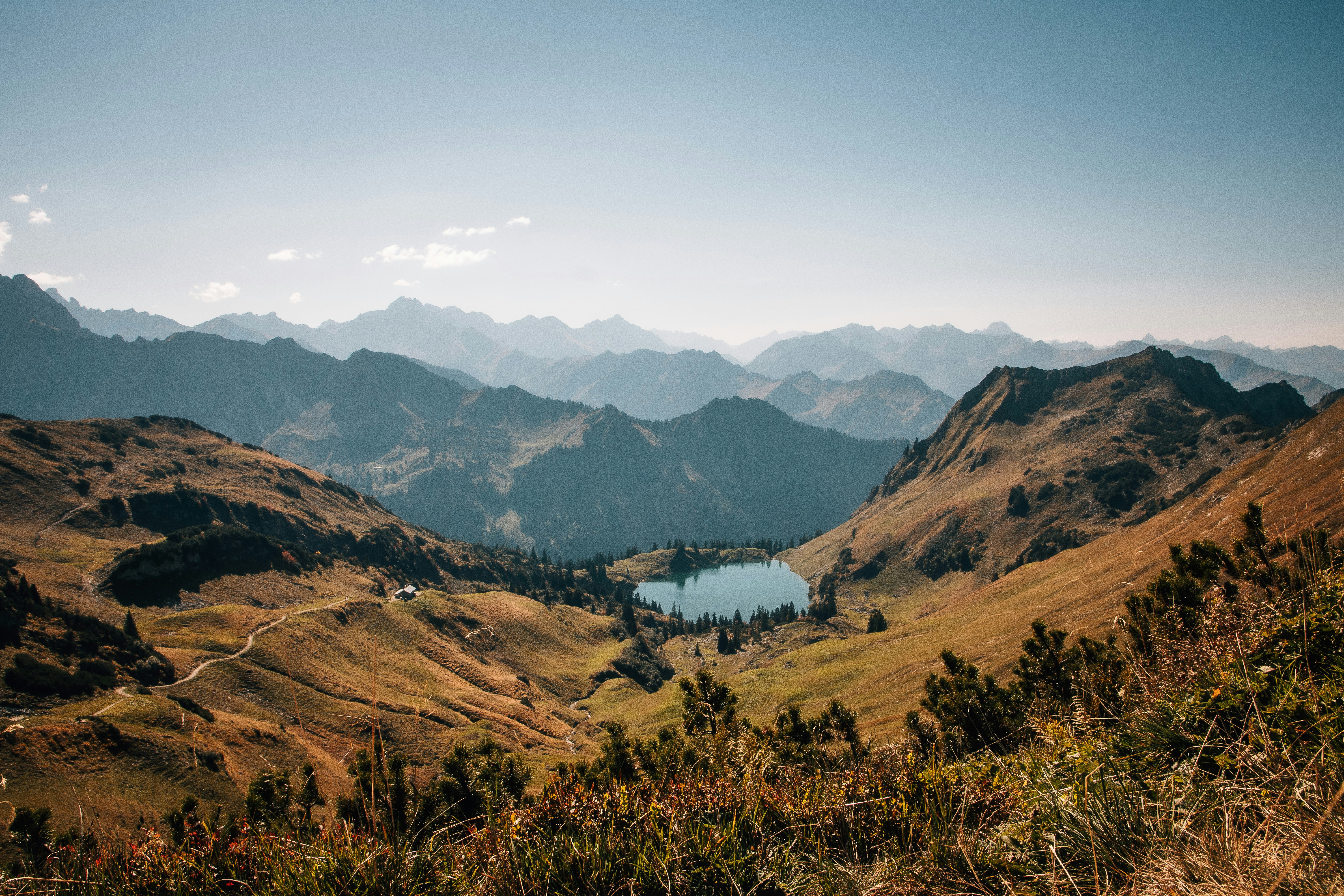A small alpine lake nestled in a valley surrounded by rugged mountain peaks
