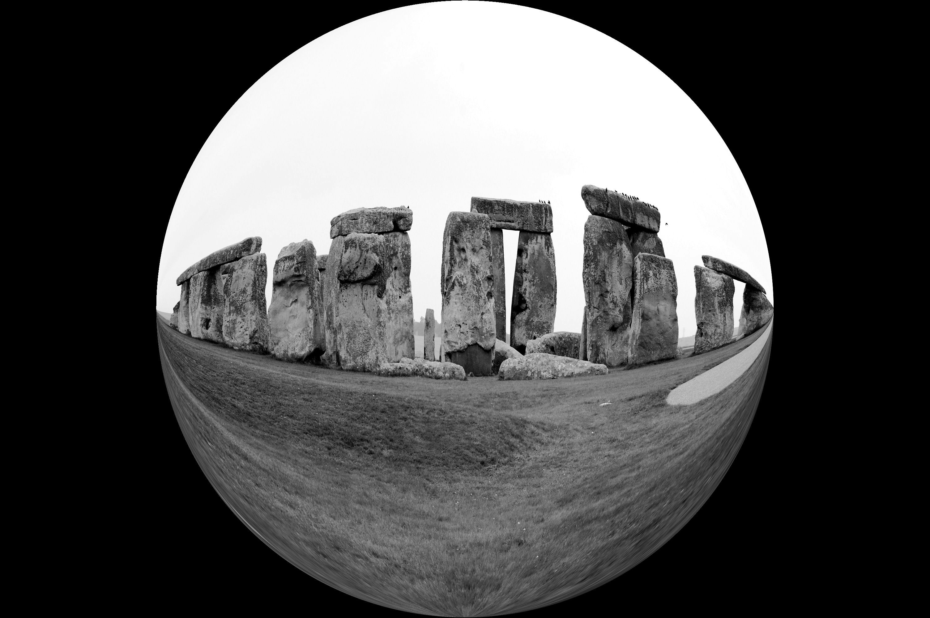 Stonehenge megaliths in a black and white fisheye view on a cloudy day