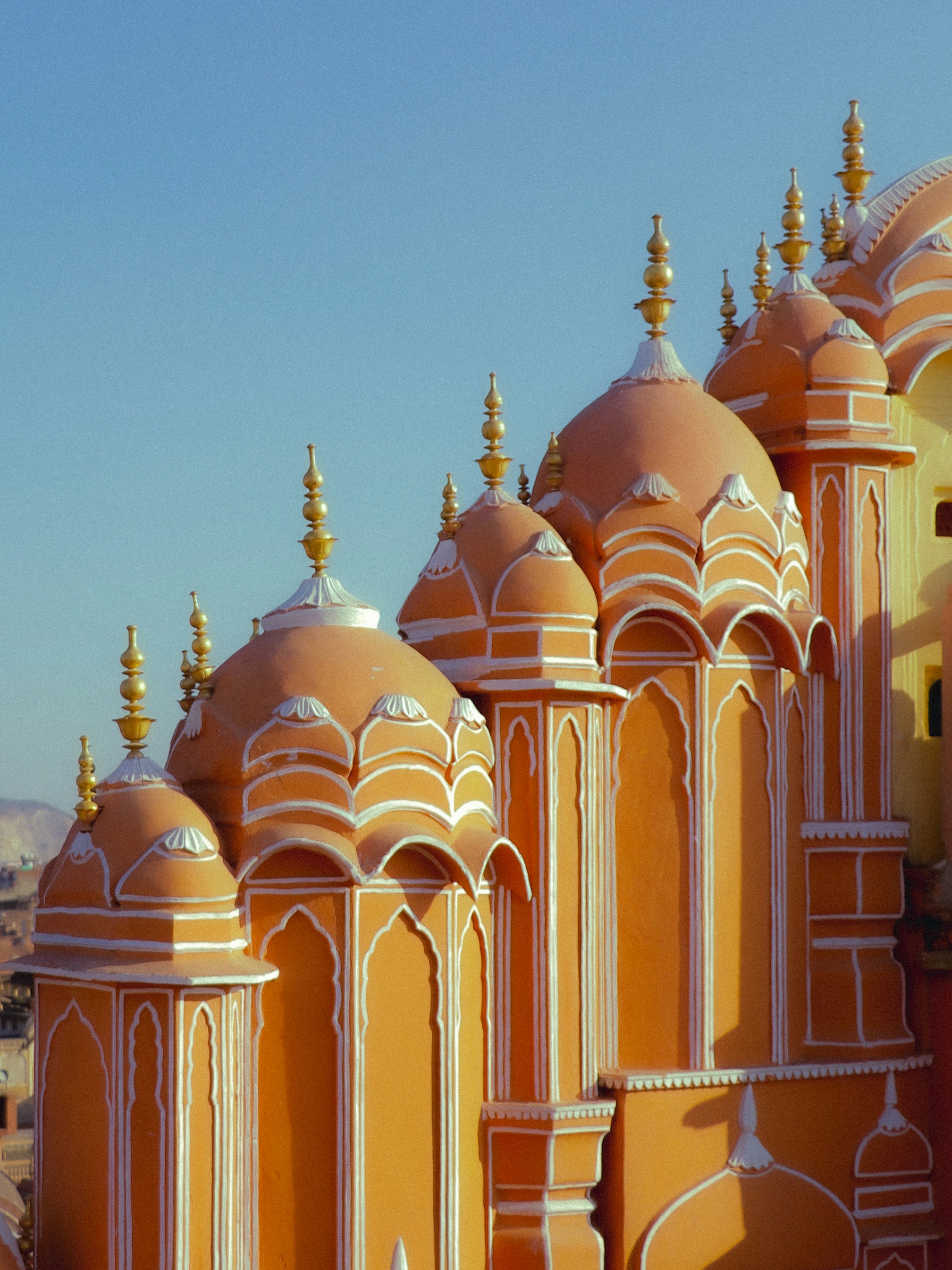 Orange domes with white trim and gold finials at Hawa Mahal in Jaipur