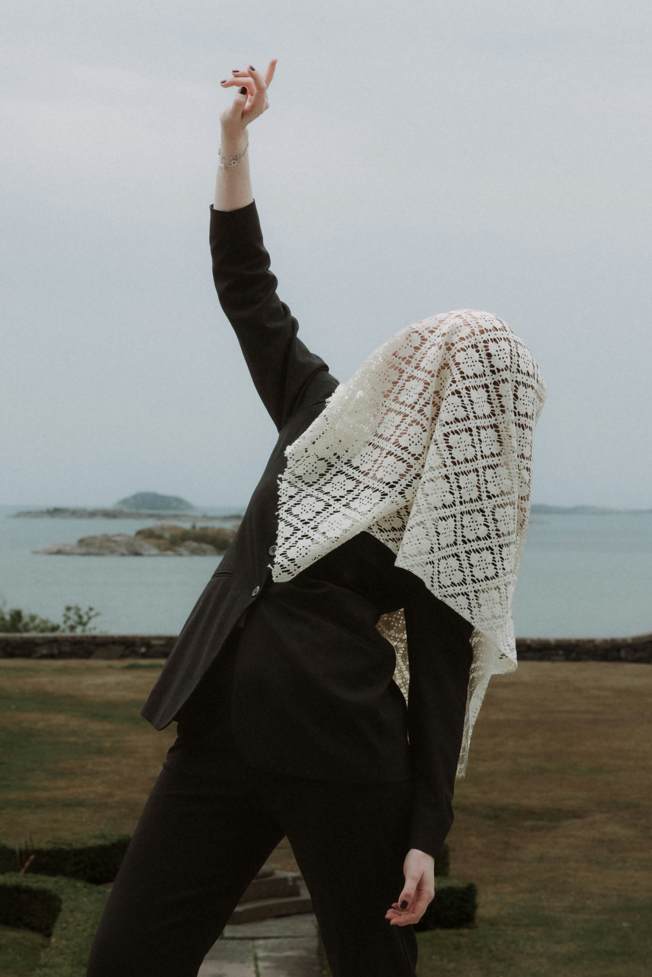 Une personne en costume noir avec un voile en dentelle sur la tête