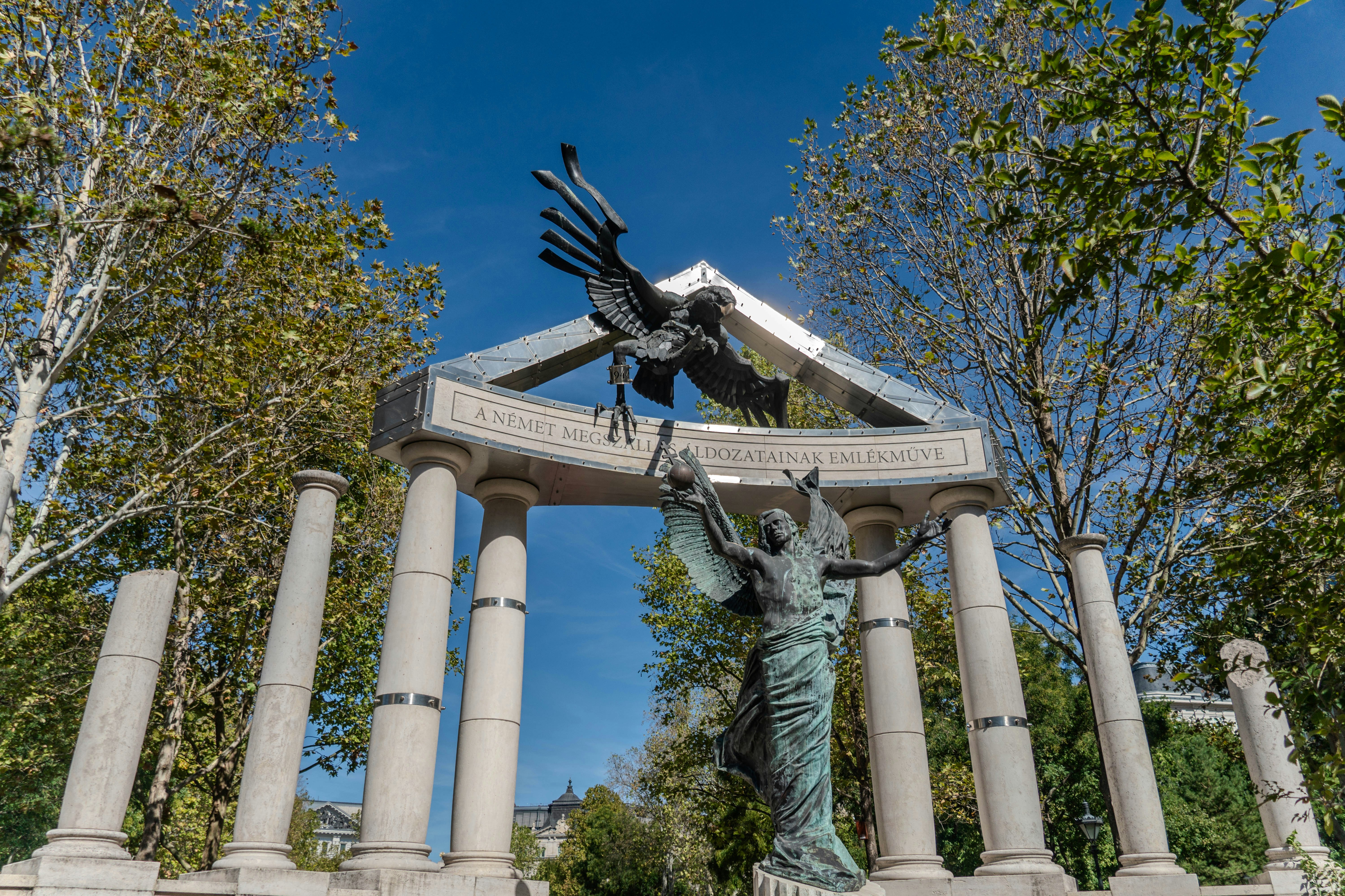 A monumental sculpture featuring a bronze eagle above classical columns and a winged figure