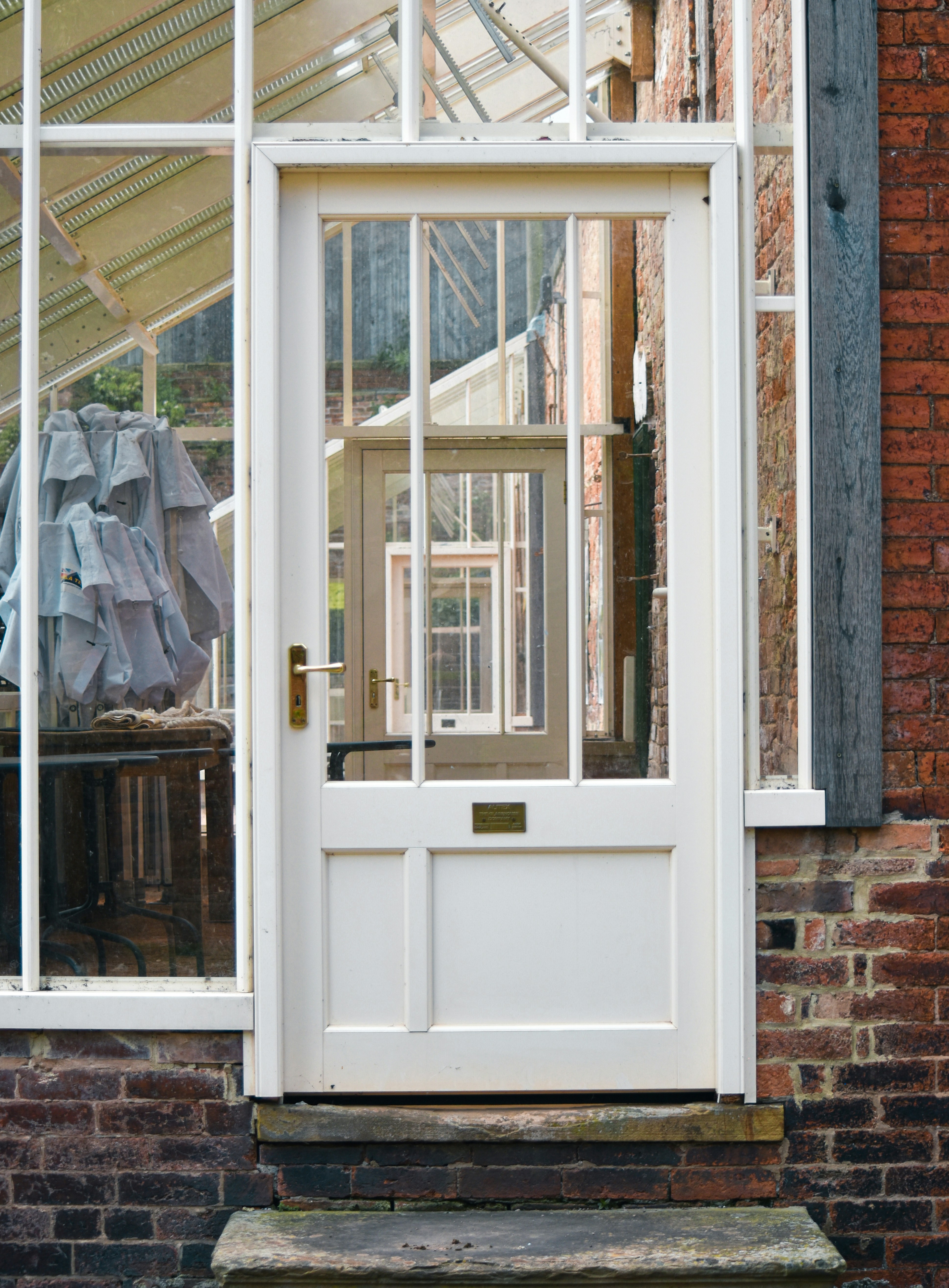 White glass door in brick greenhouse - Free Photo on Unsplash