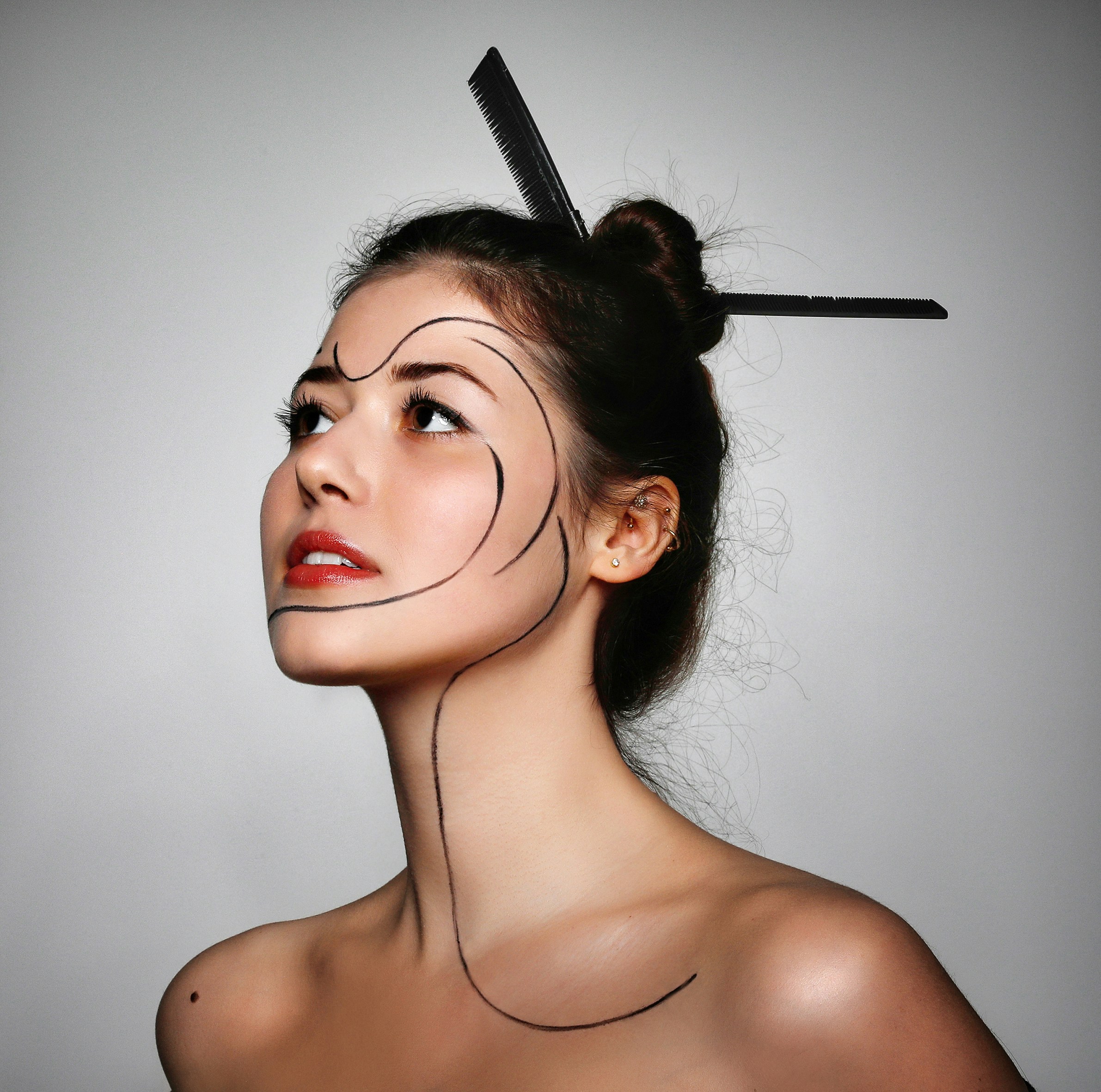 A woman with black lines drawn on her face and combs in her hair