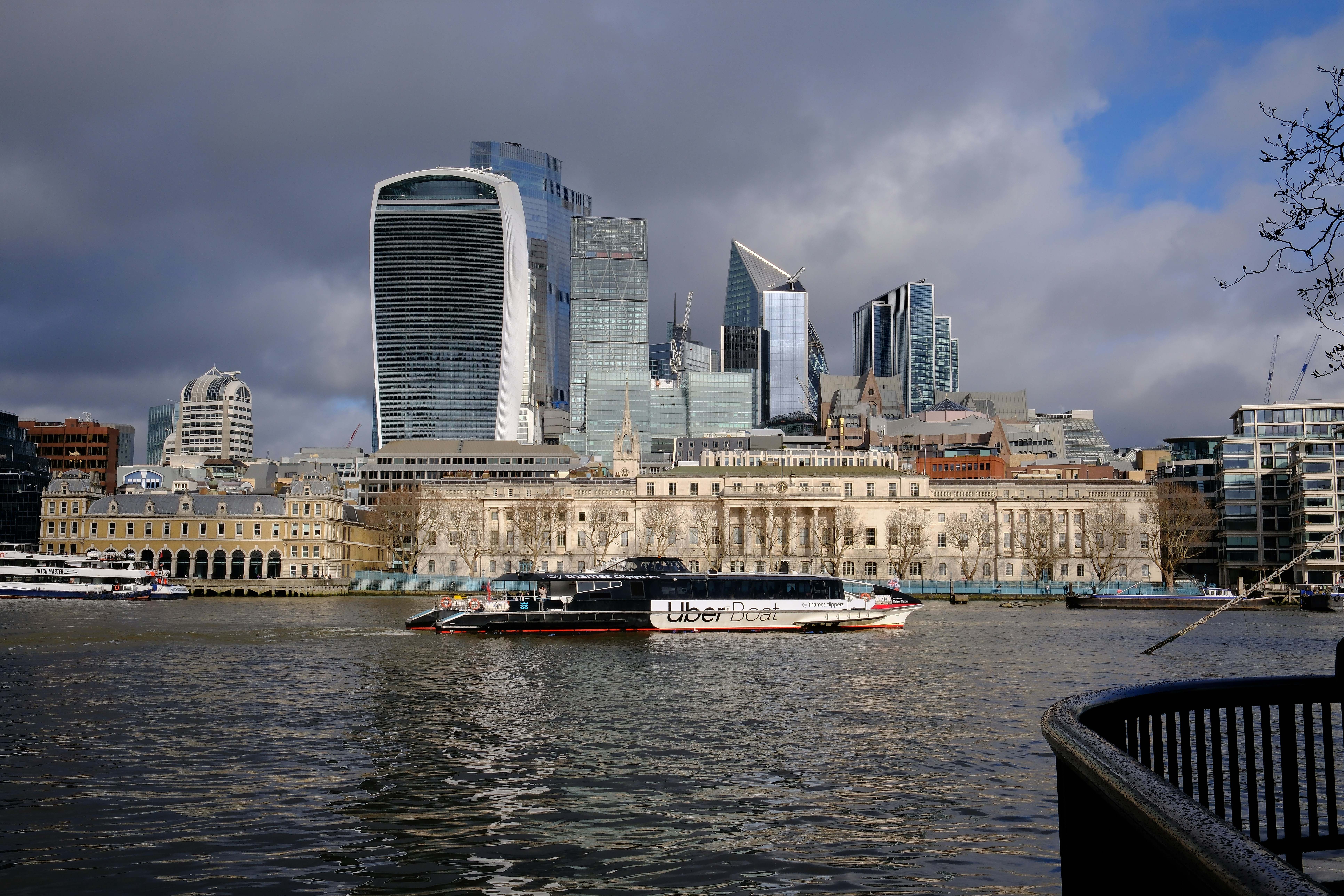 A river boat on the Thames in London with the city skyline behind