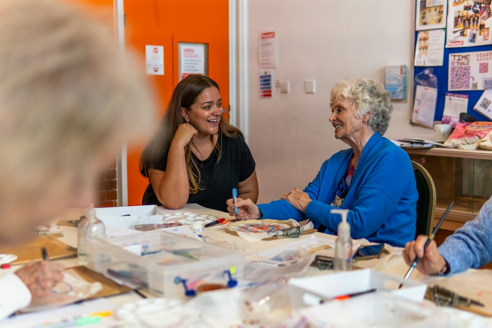 Des personnes autour d’une table d’atelier, crayons et feutres devant elles