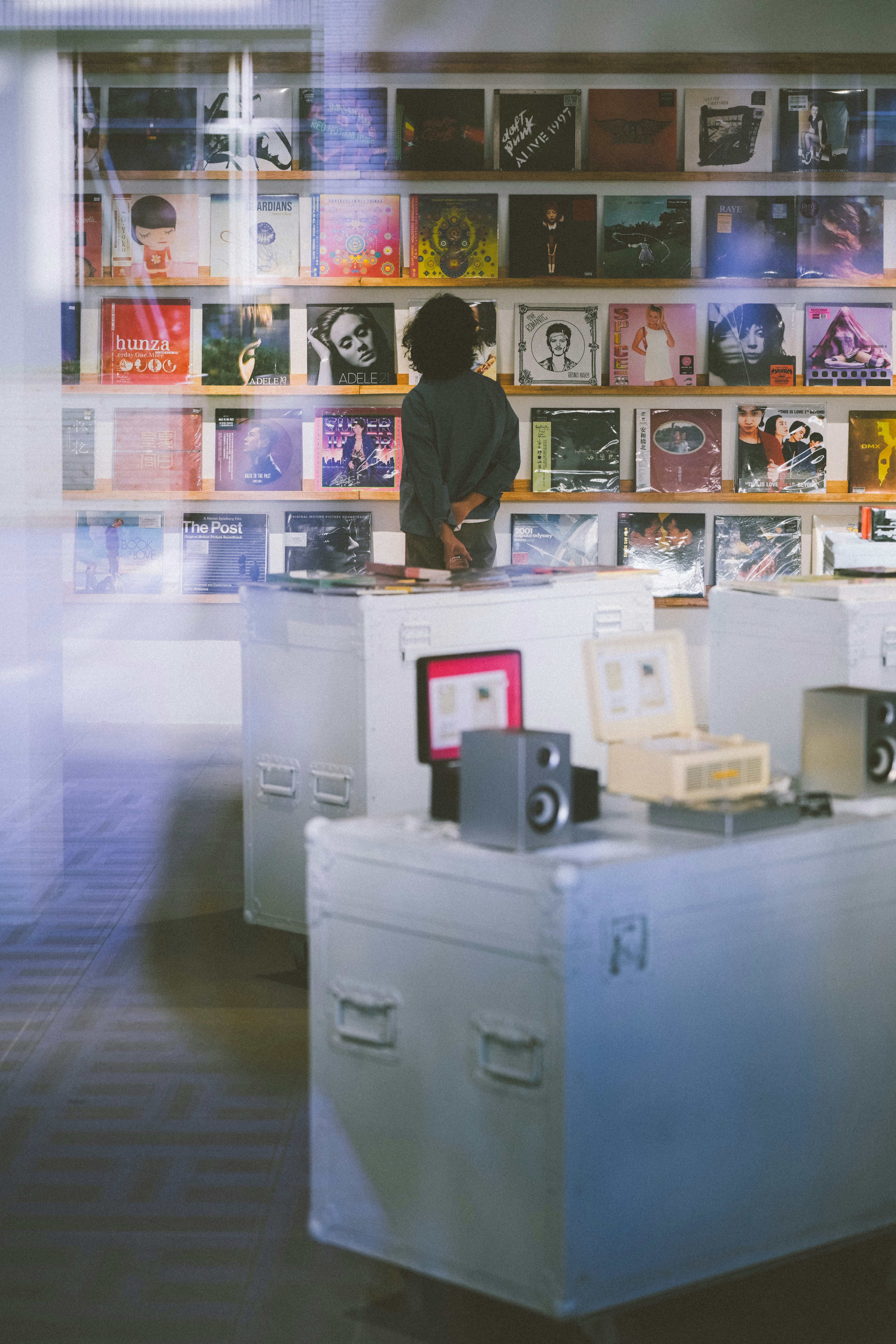 A person looking at vinyl records displayed on shelves in a music store