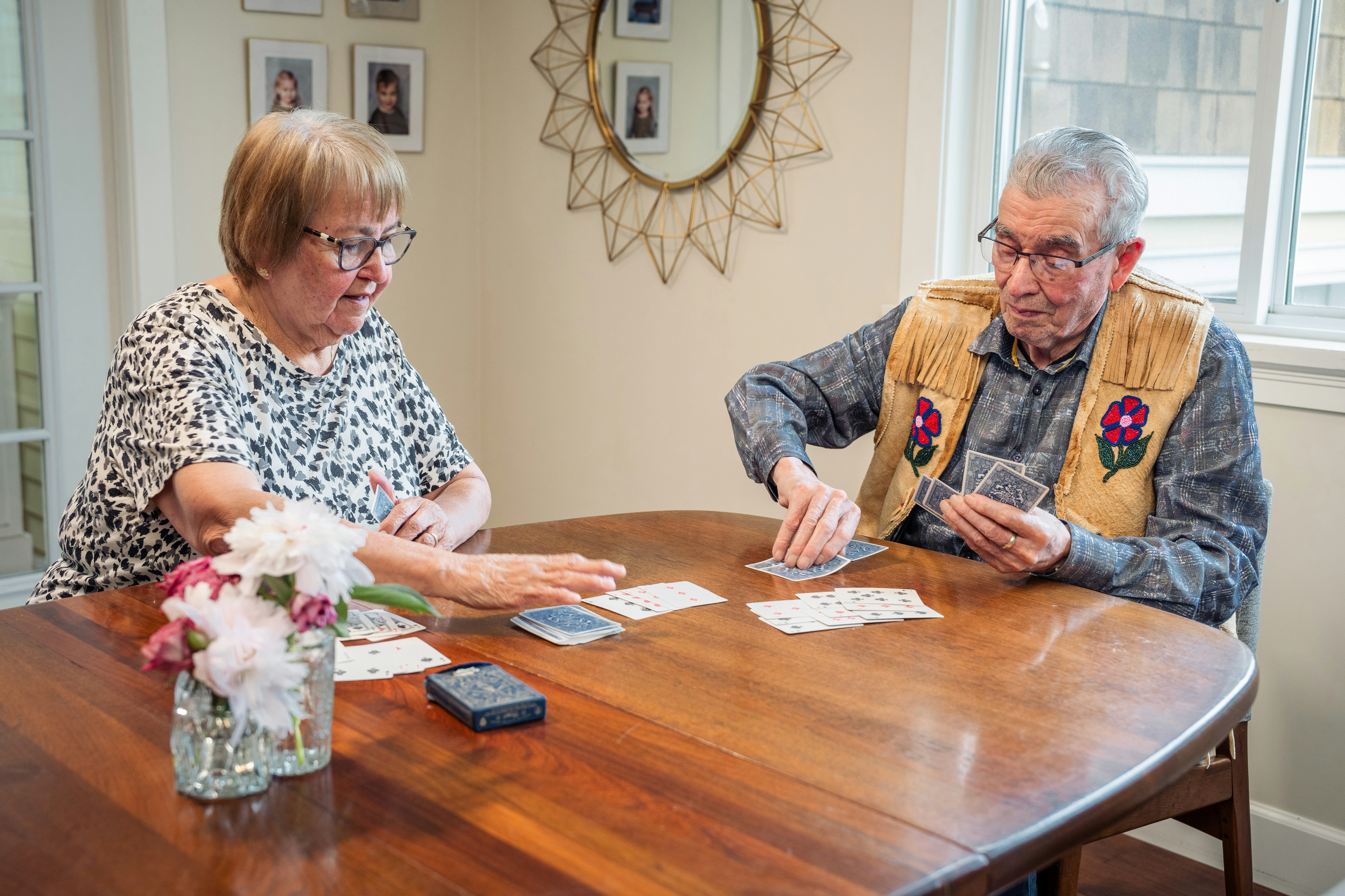 An older adult using a banking app on a smartphone while seated at a table