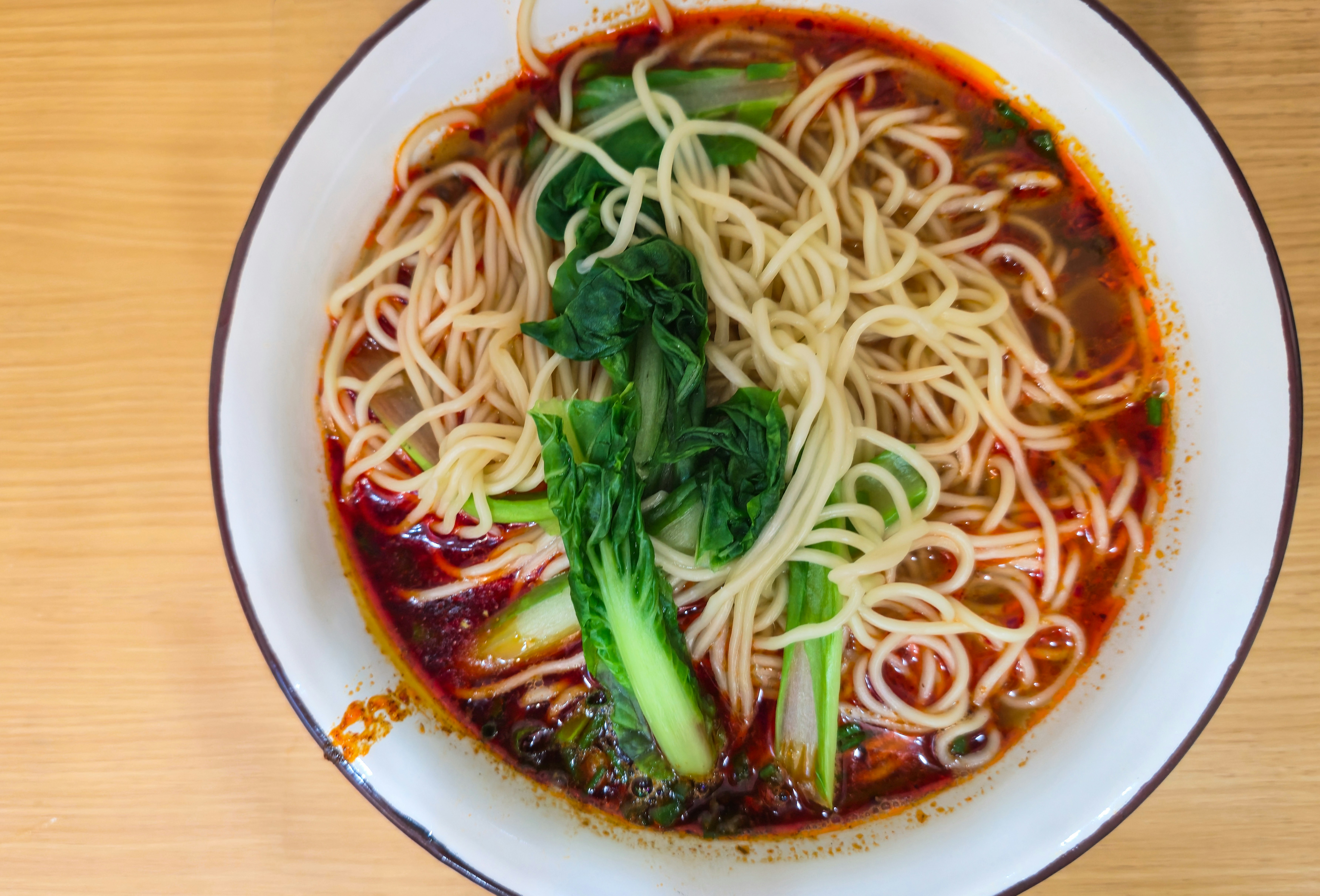 Thin wheat noodles in a spicy chili oil broth with bok choy