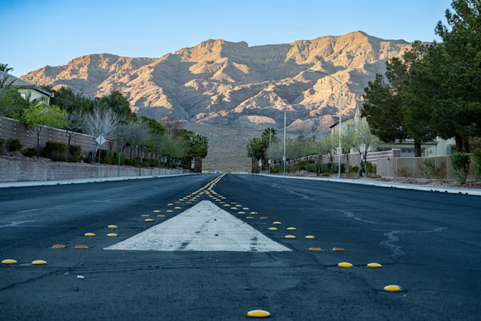 A suburban street in a desert neighborhood leading toward a mountain, similar to the Las Vegas valley where sellers now outnumber buyers more than two to one