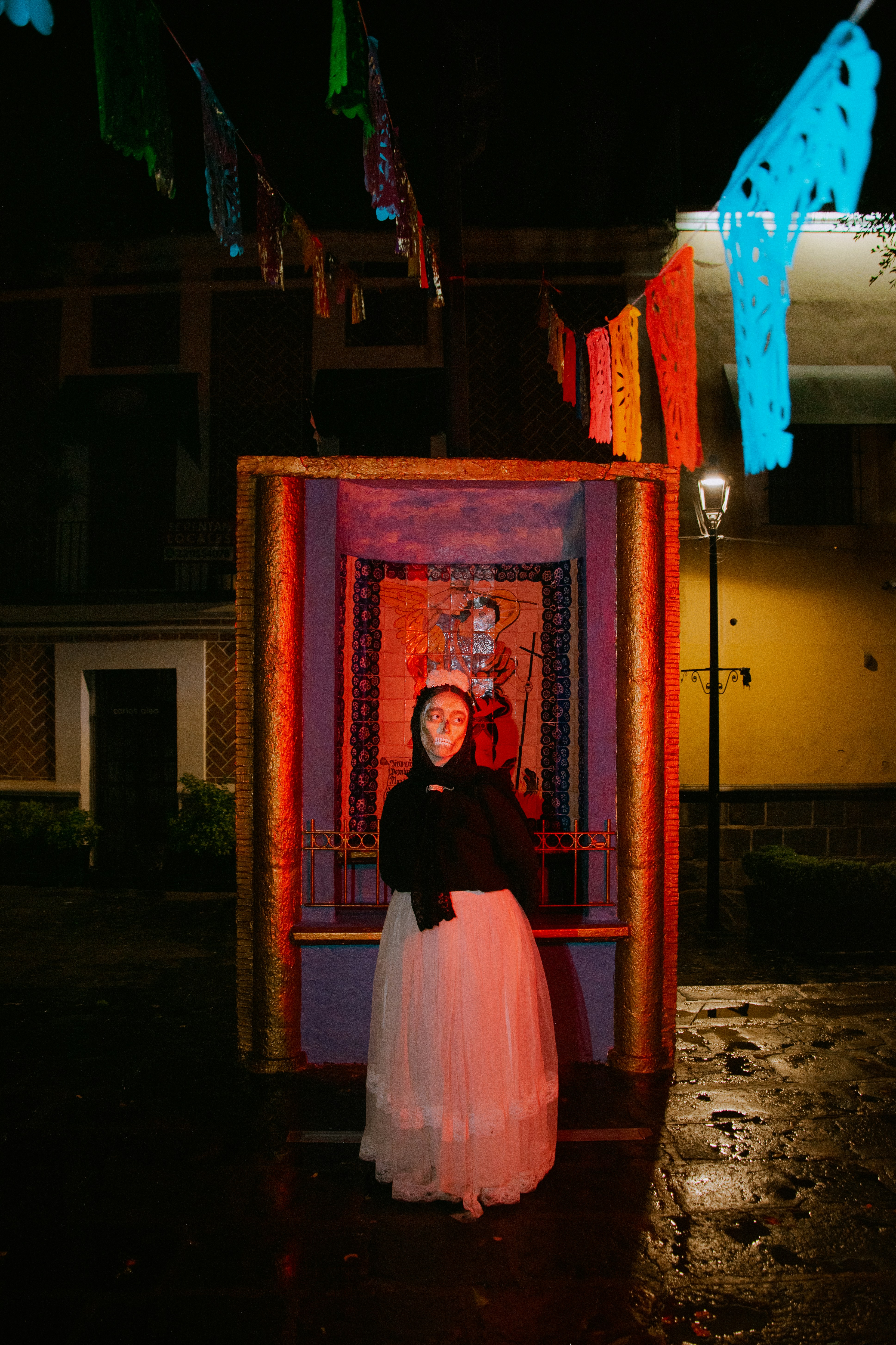 Fotomural A person with skull makeup in a long skirt standing before a shrine