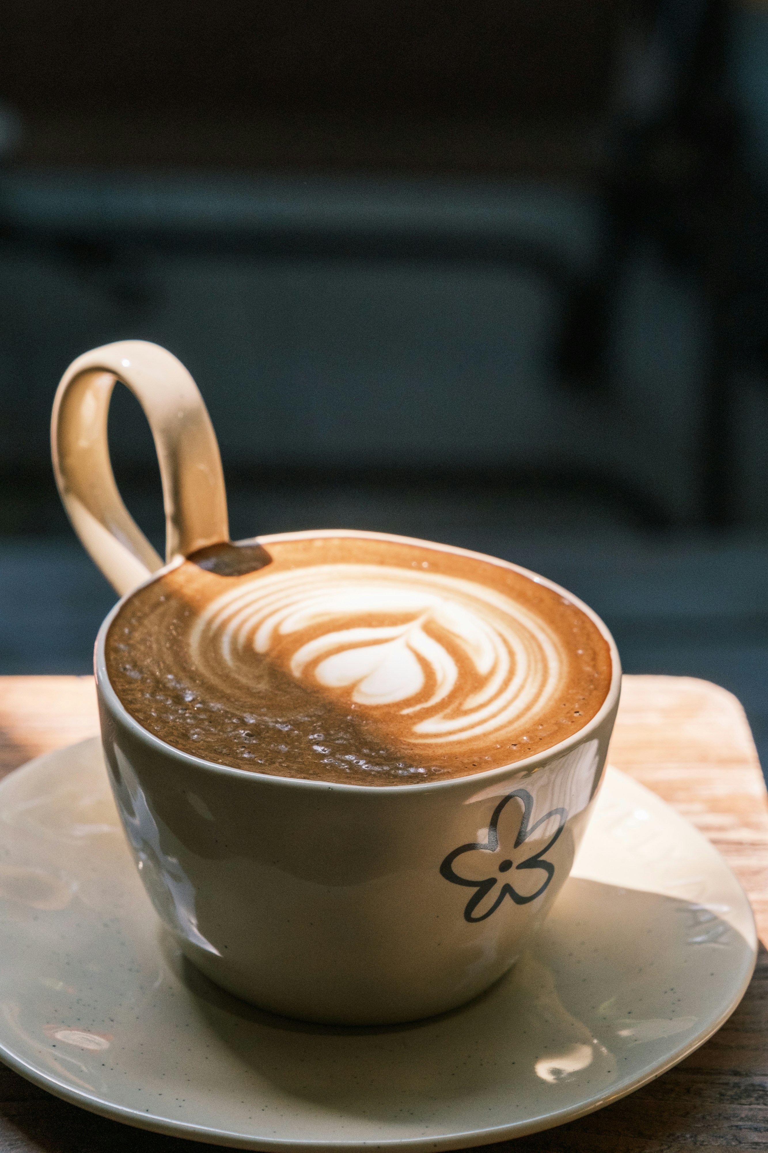 A cup of latte with heart latte art on a saucer