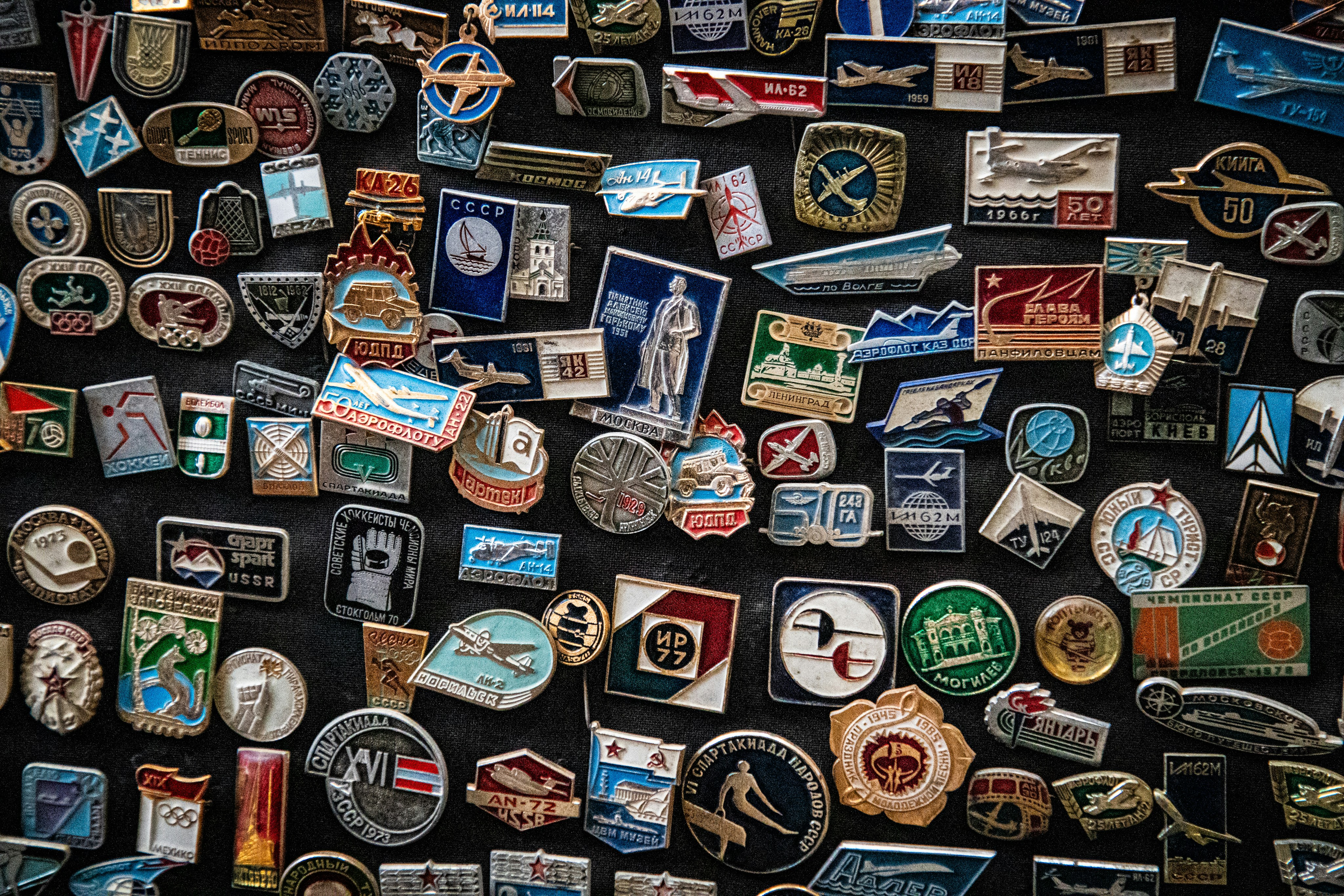 A collection of vintage Soviet enamel pins featuring airplanes and various commemorative symbols