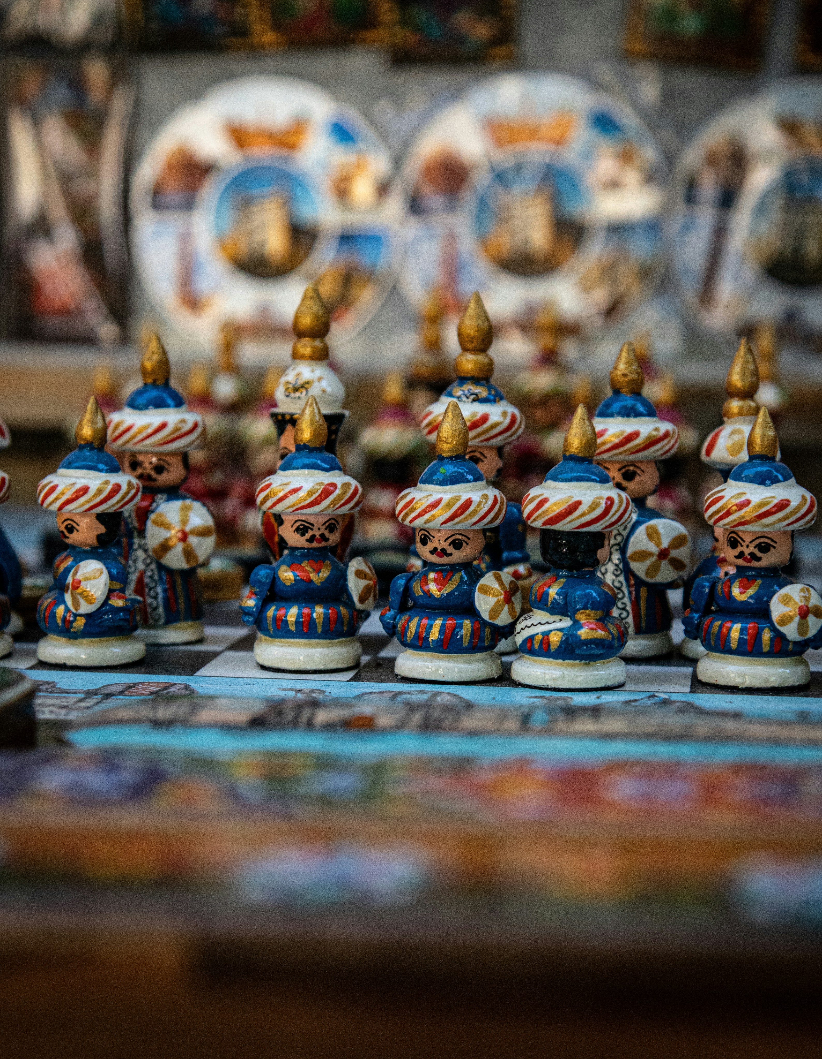 Hand-painted wooden chess pieces with turbans on a patterned board