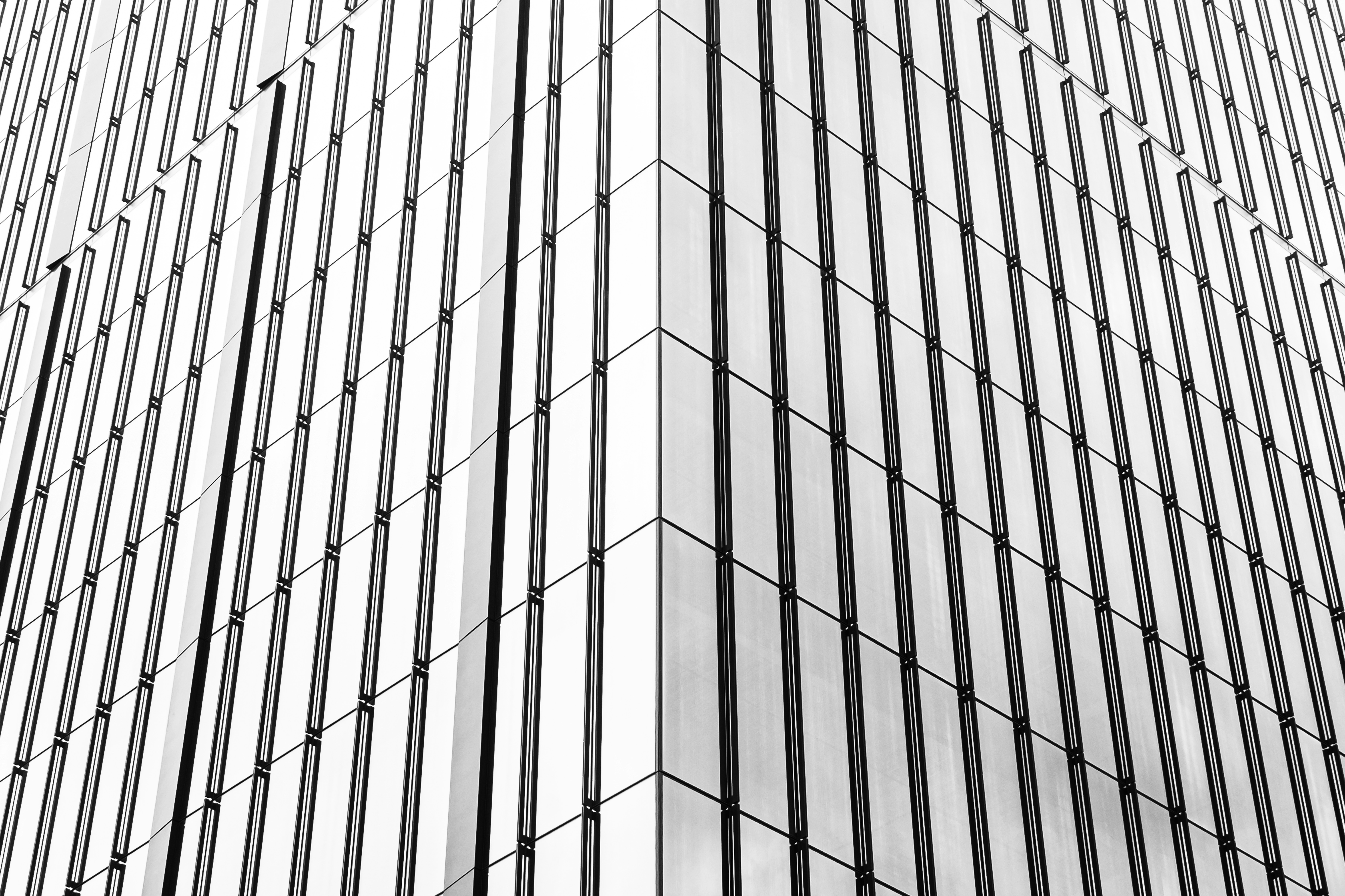 The corner of a modern skyscraper with vertical glass panels and metal frames