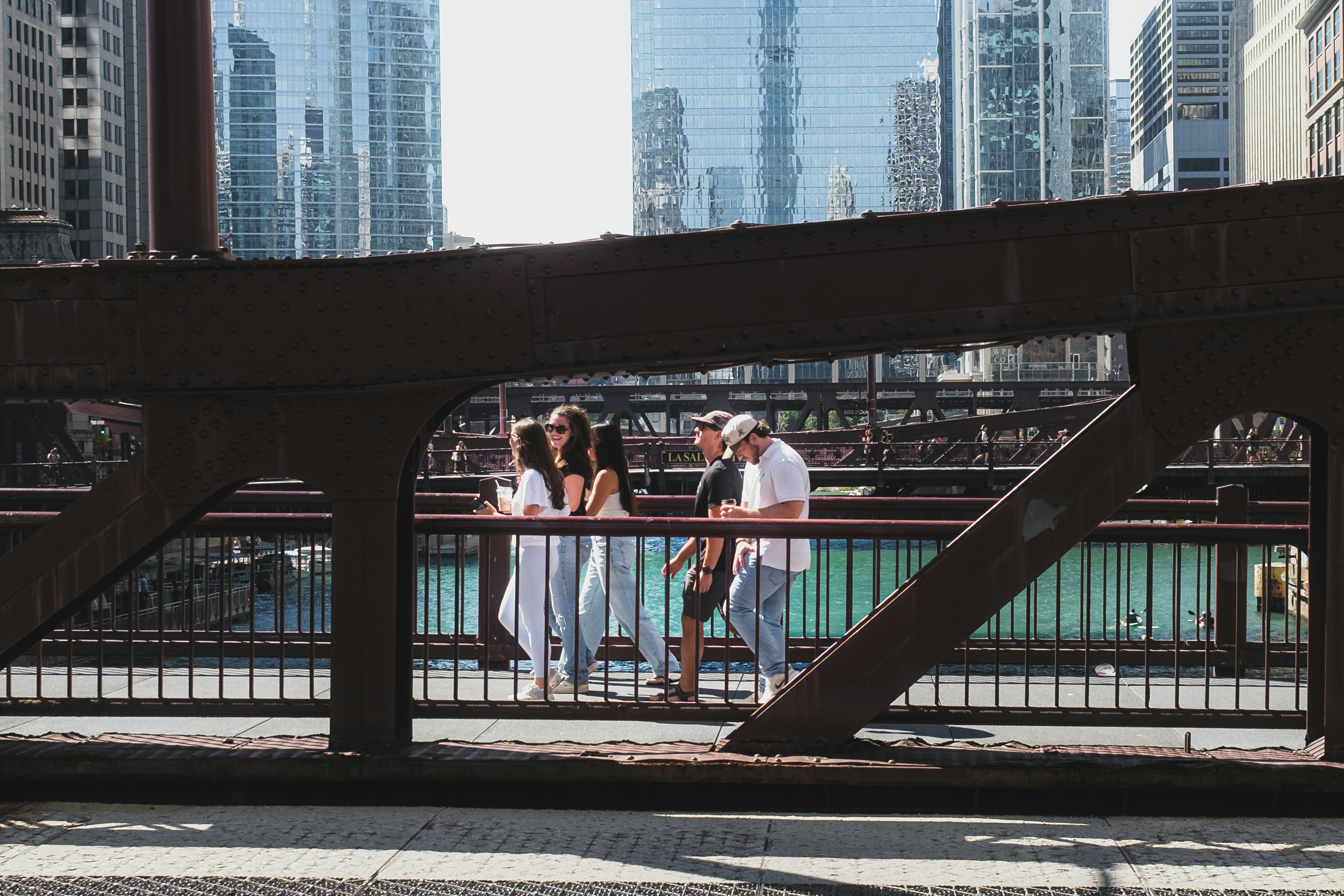 A group of people walking across a metal bridge in Chicago