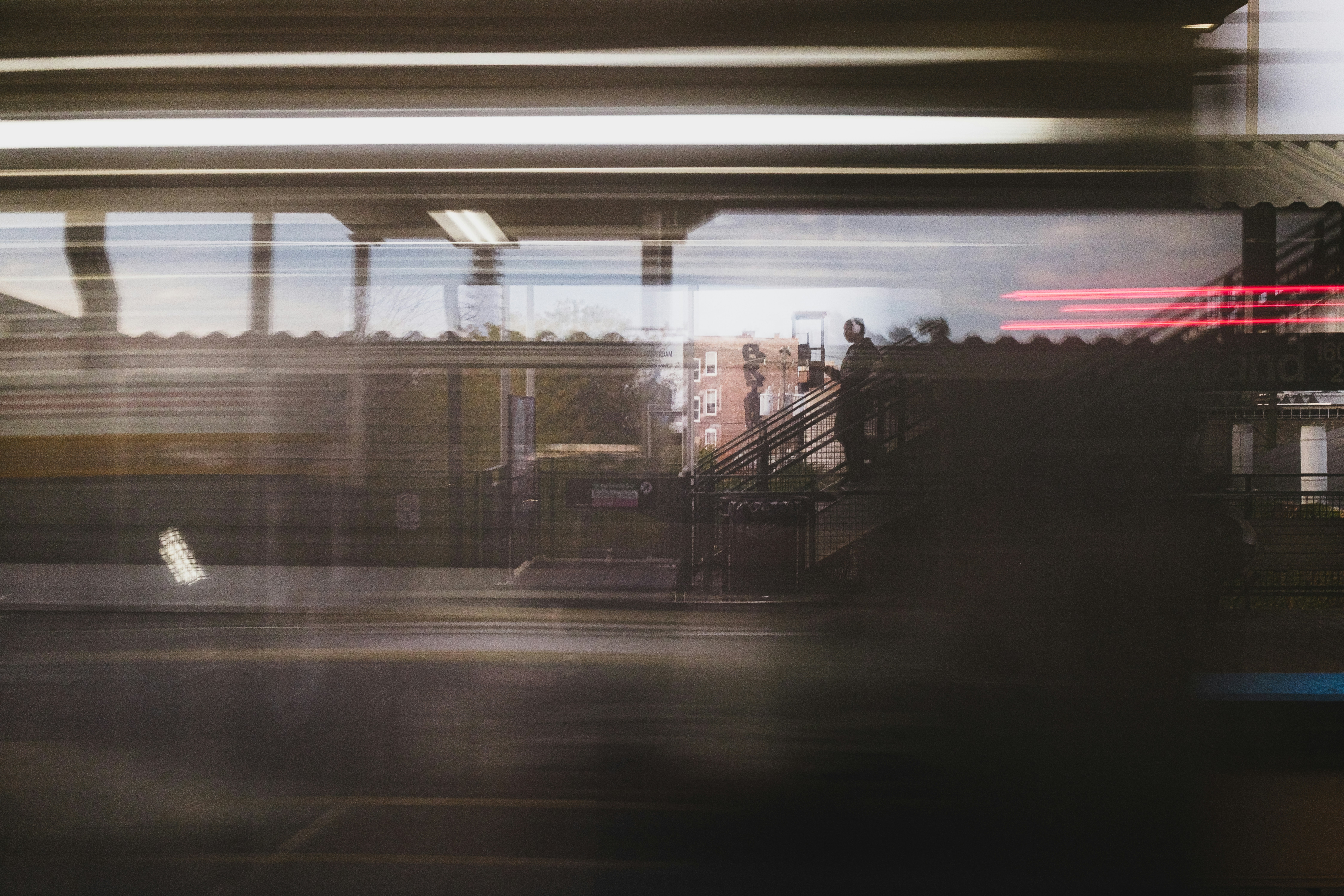 A person walking up stairs at a train station in a long exposure