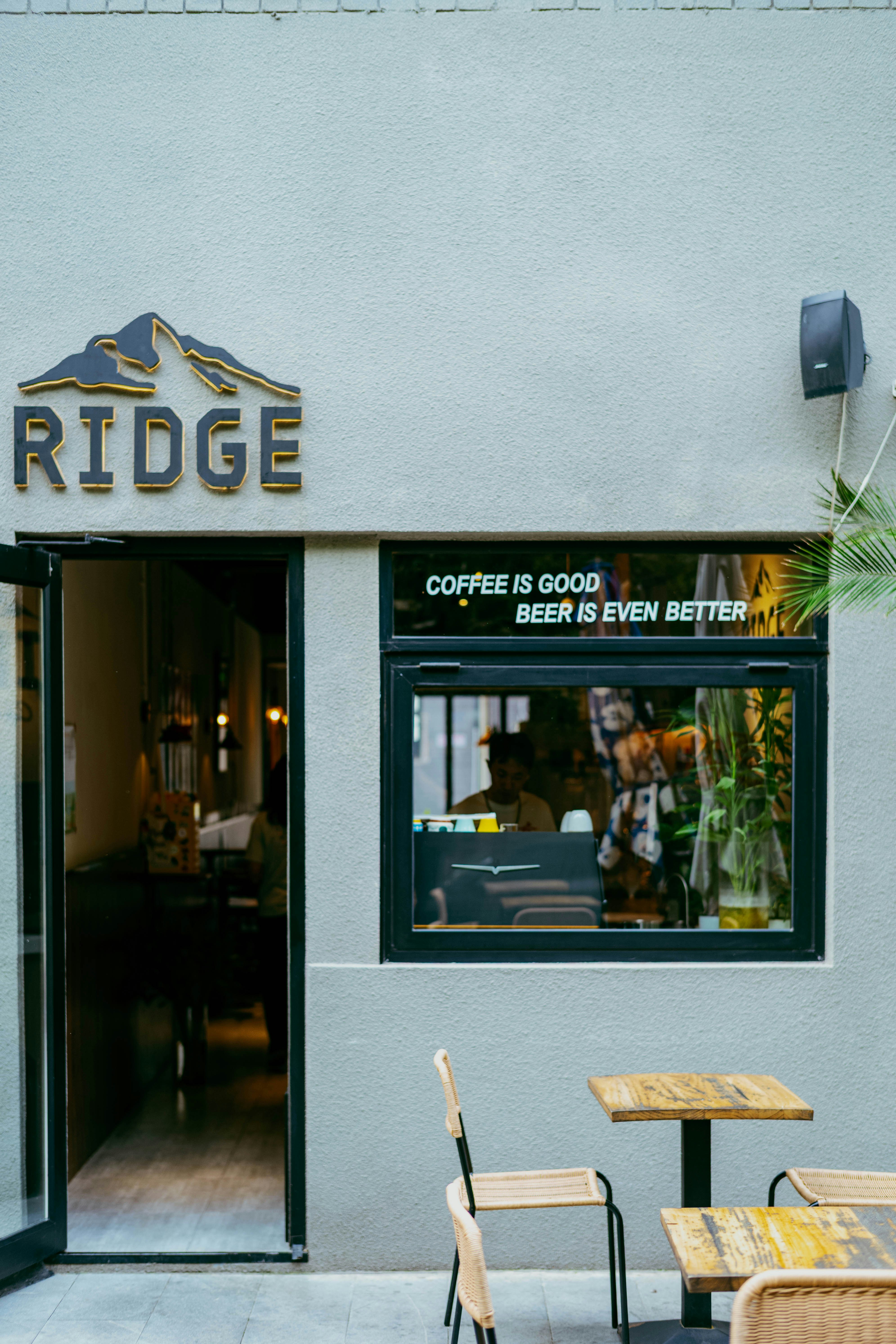「RIDGE」と書かれた看板と文字の窓があるカフェの入口