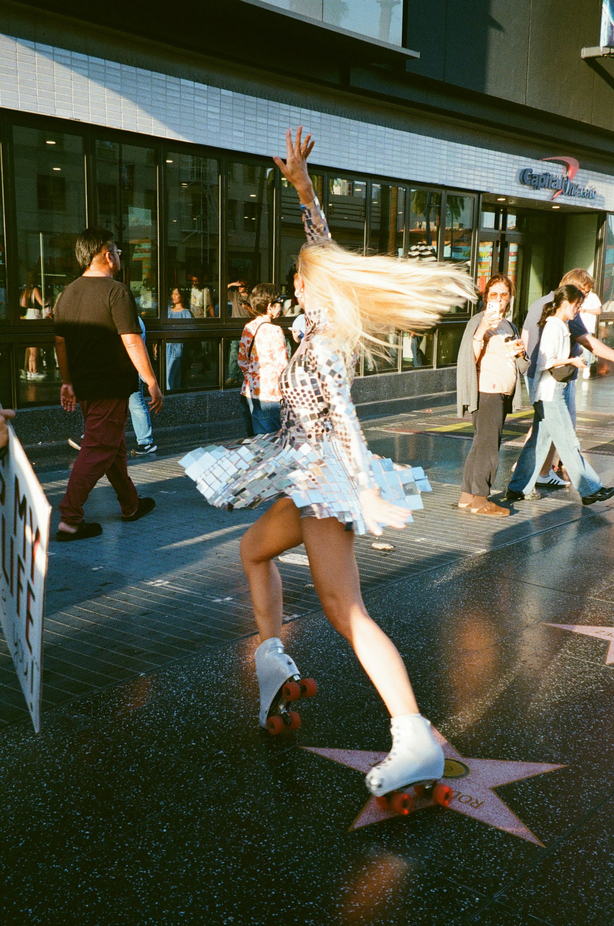 A person in a reflective mirror dress roller skating on the Hollywood Walk of Fame