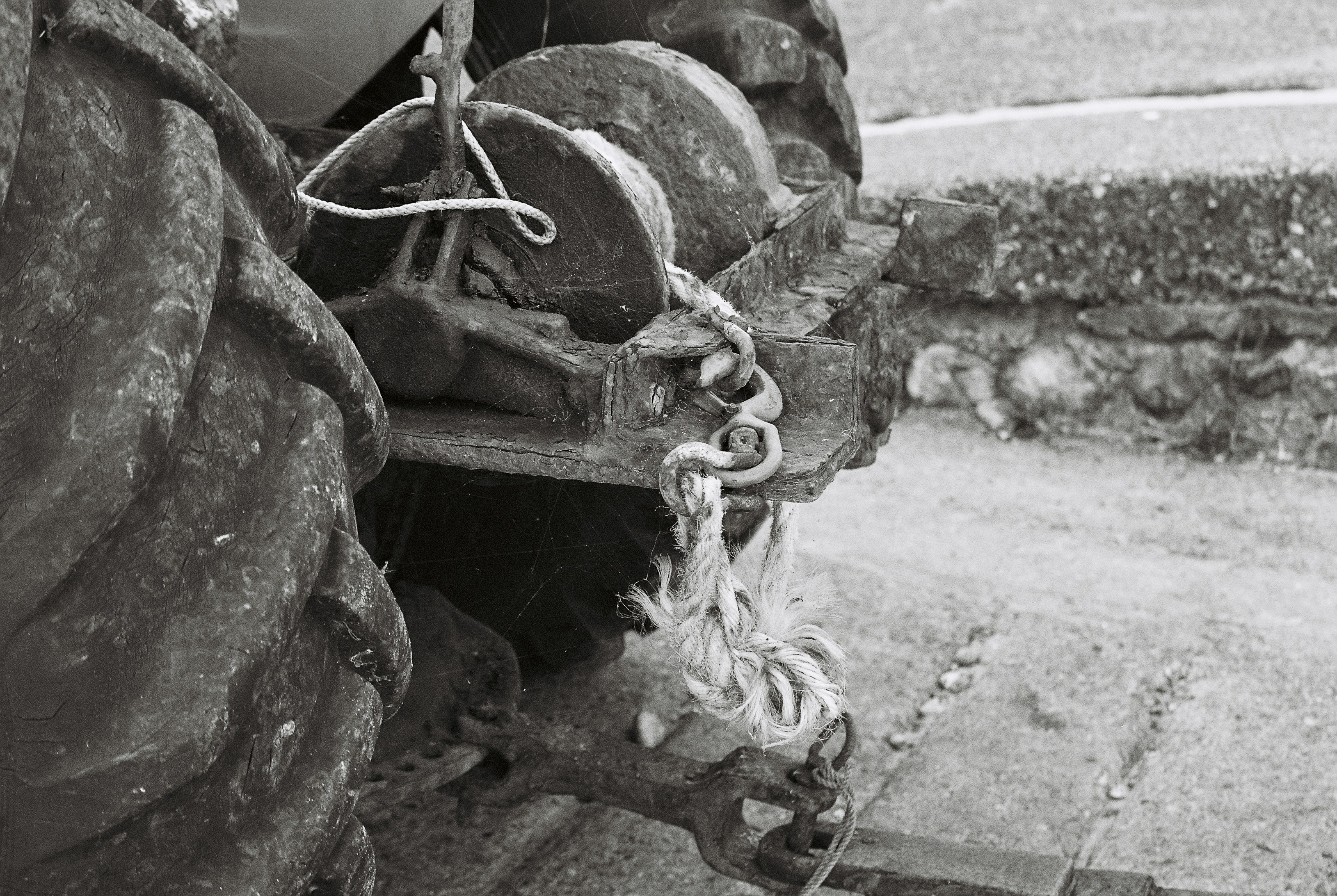A winch drum with rope on a tractor beside a large rubber tyre