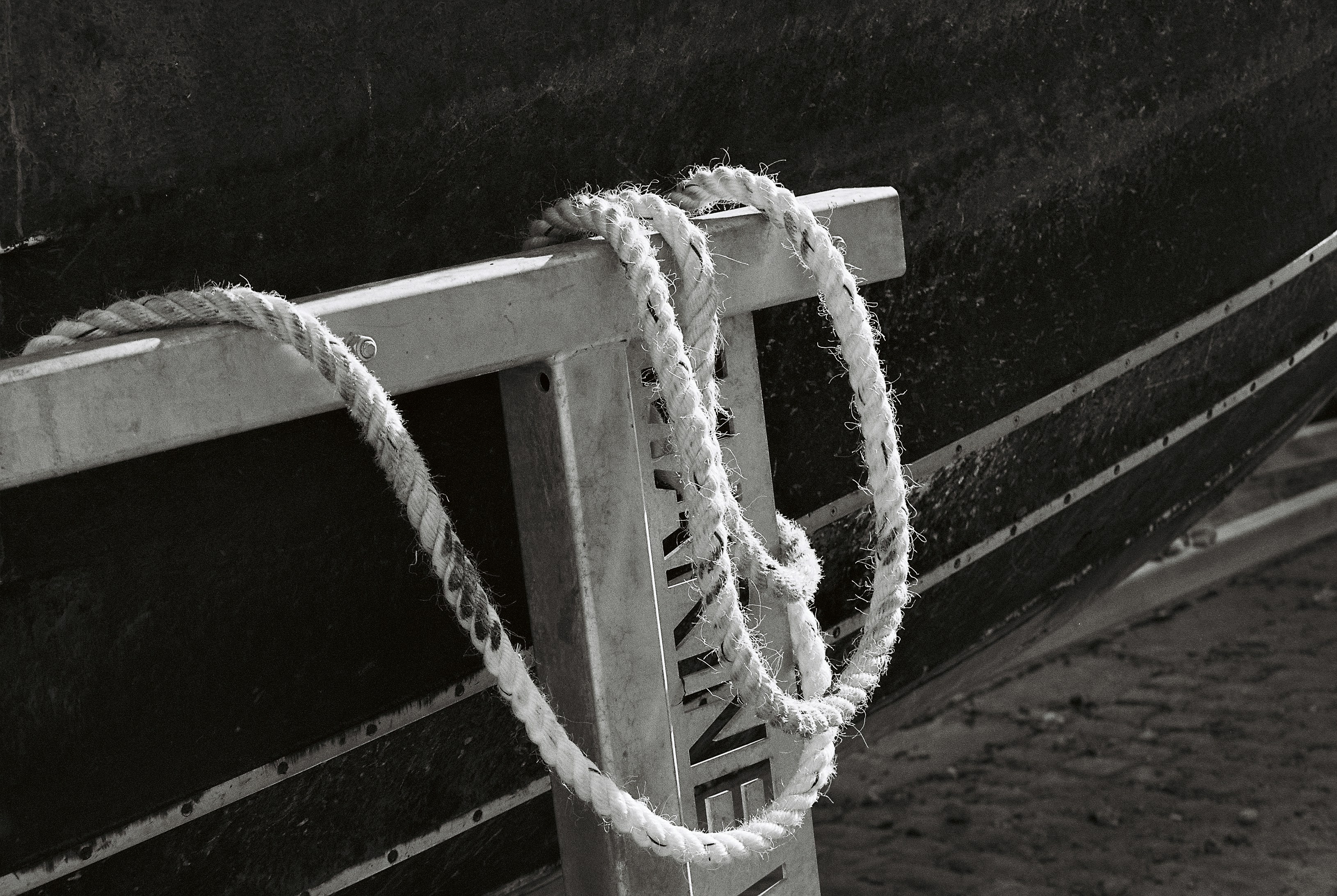 A thick rope looped over a steel frame on a boat hull