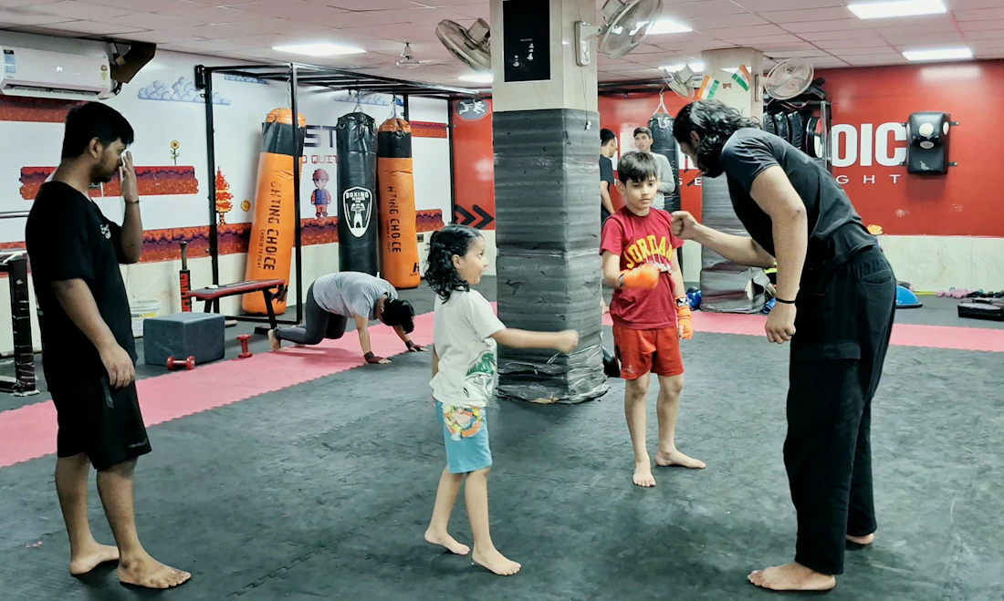 Instructor guiando a niños en una clase dentro de un gimnasio moderno