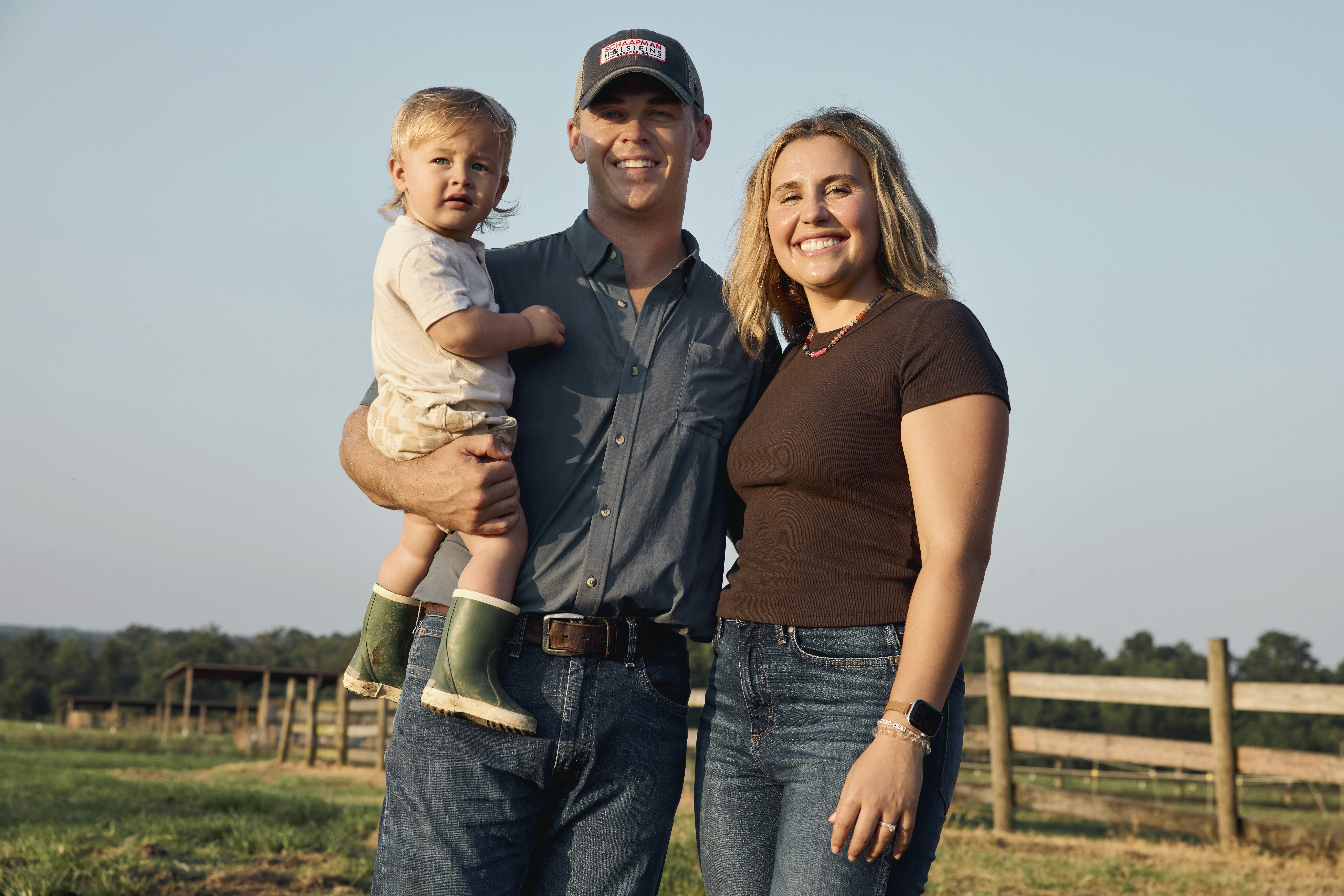 Young farming family standing together outdoors