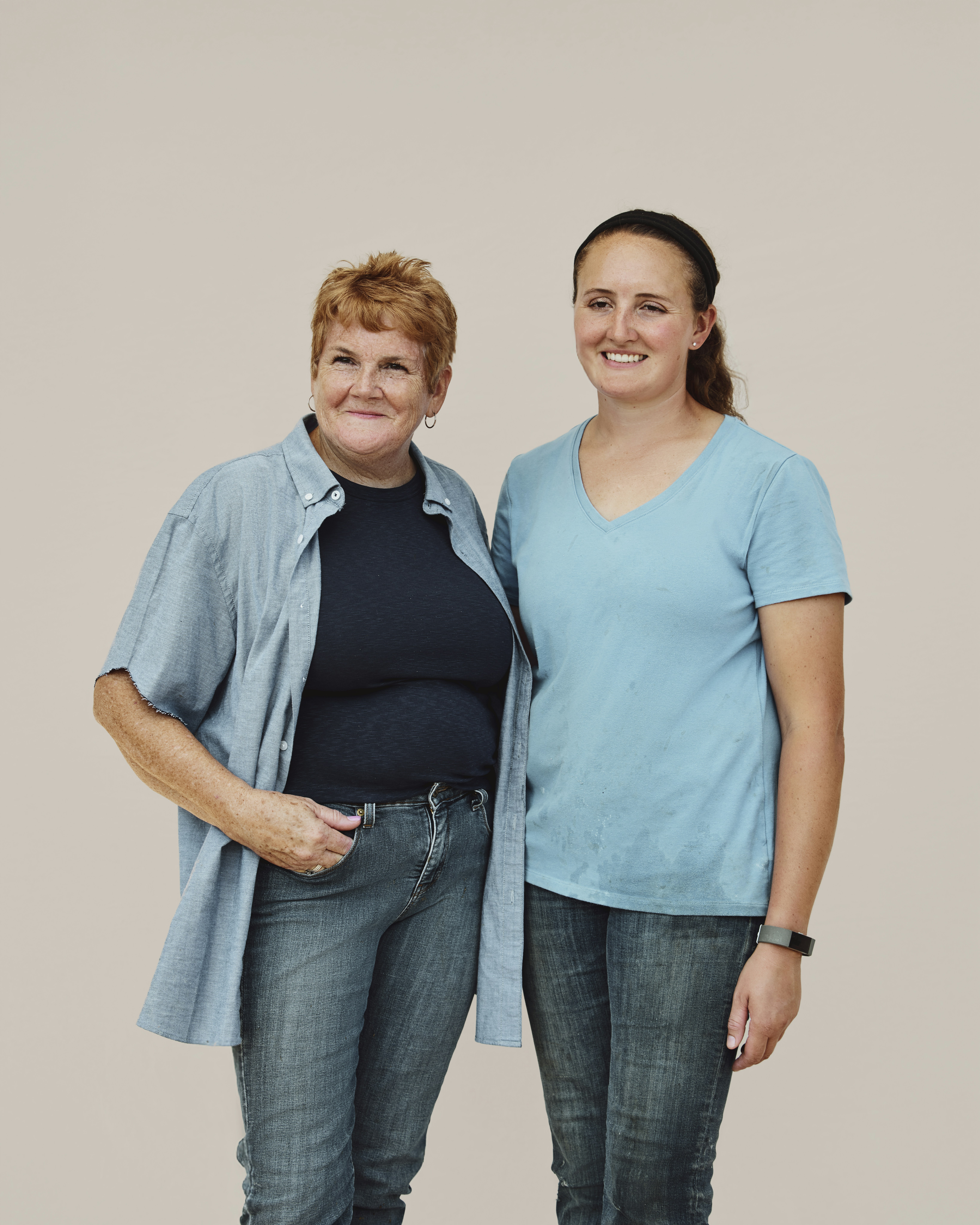 Two generations of woman dairy farmers posing together. Pennsylvania, USA.