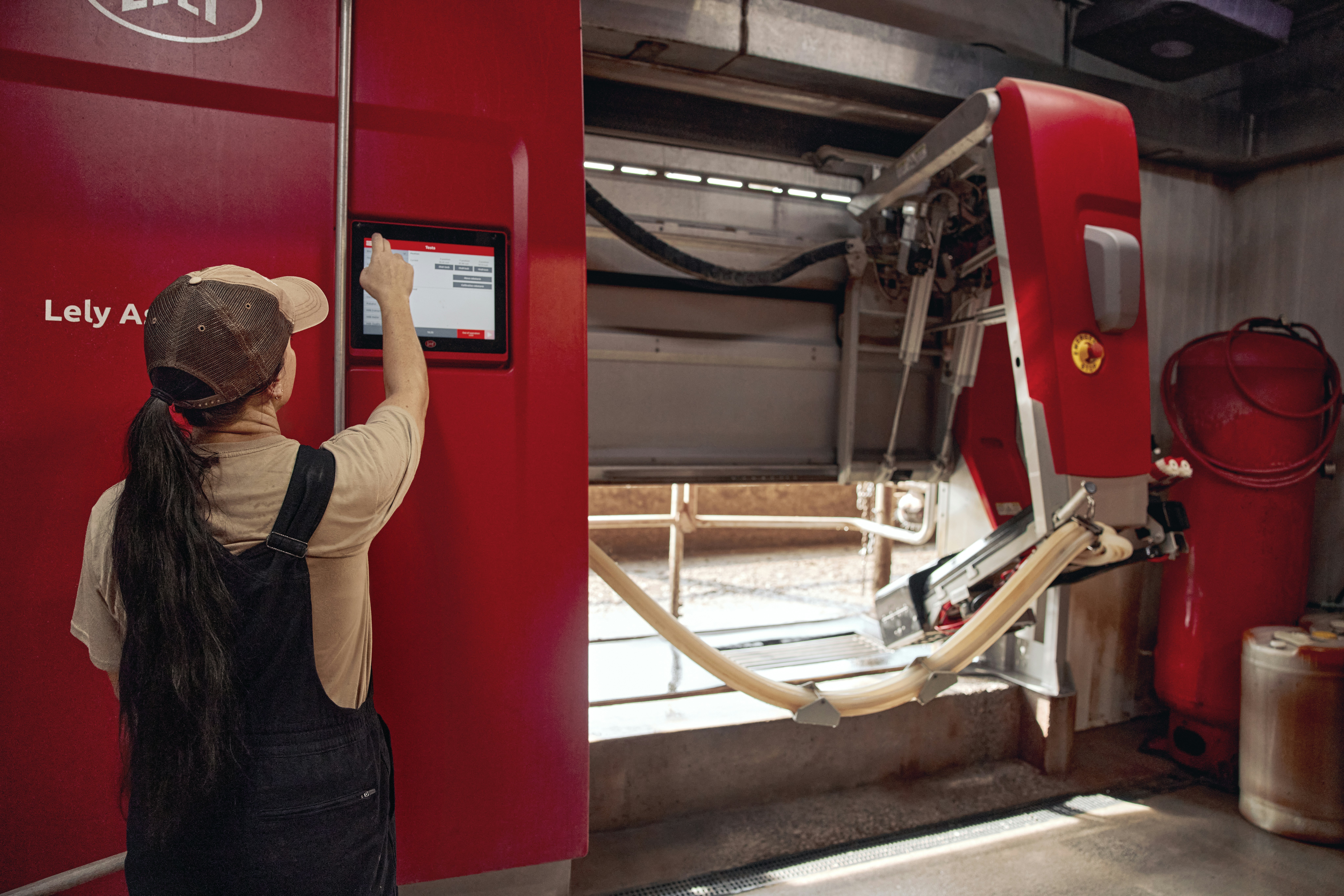 Woman operating a robotic milking unit. Ohio, USA.
