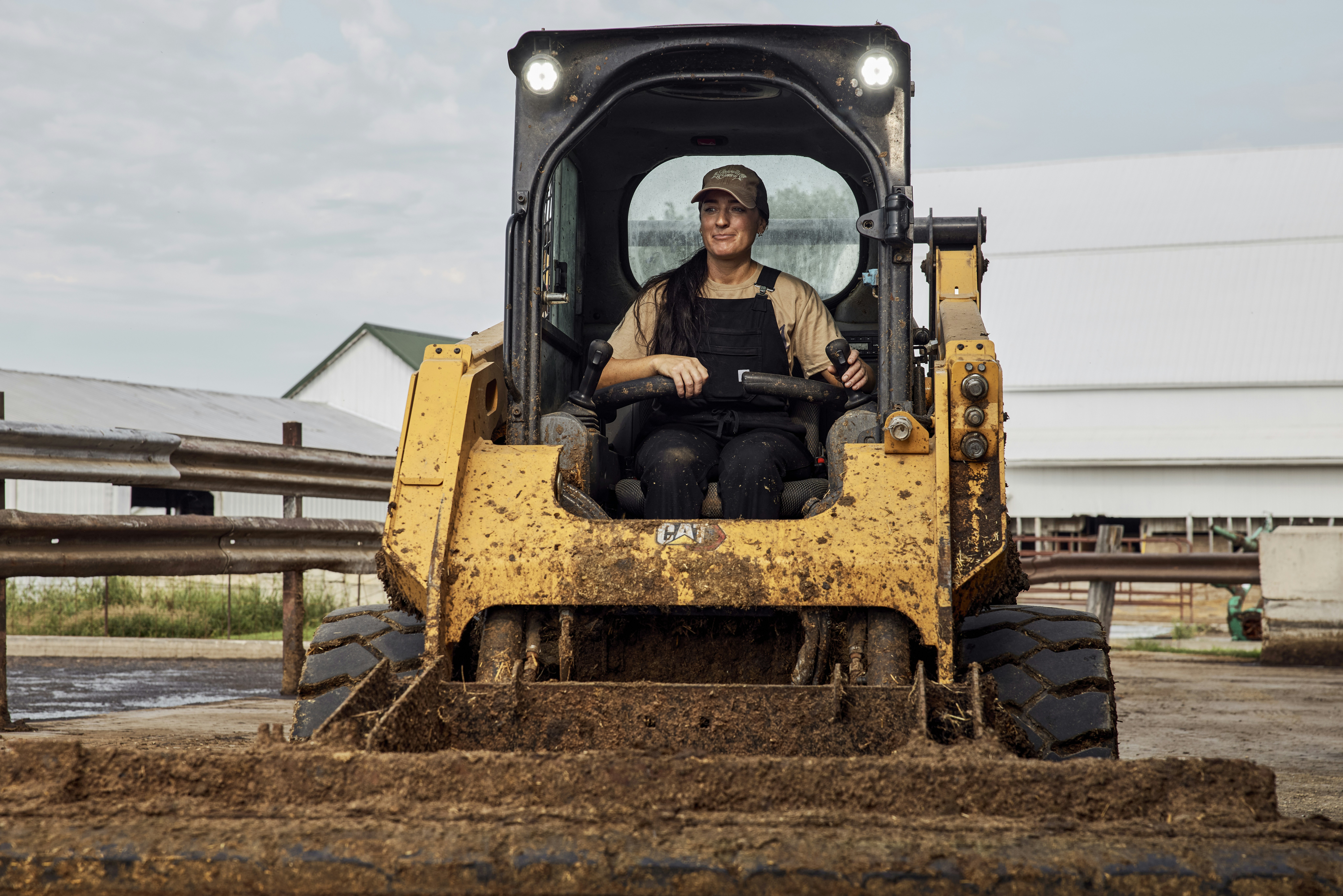 Woman operating a skid steer loader. Ohio, USA.