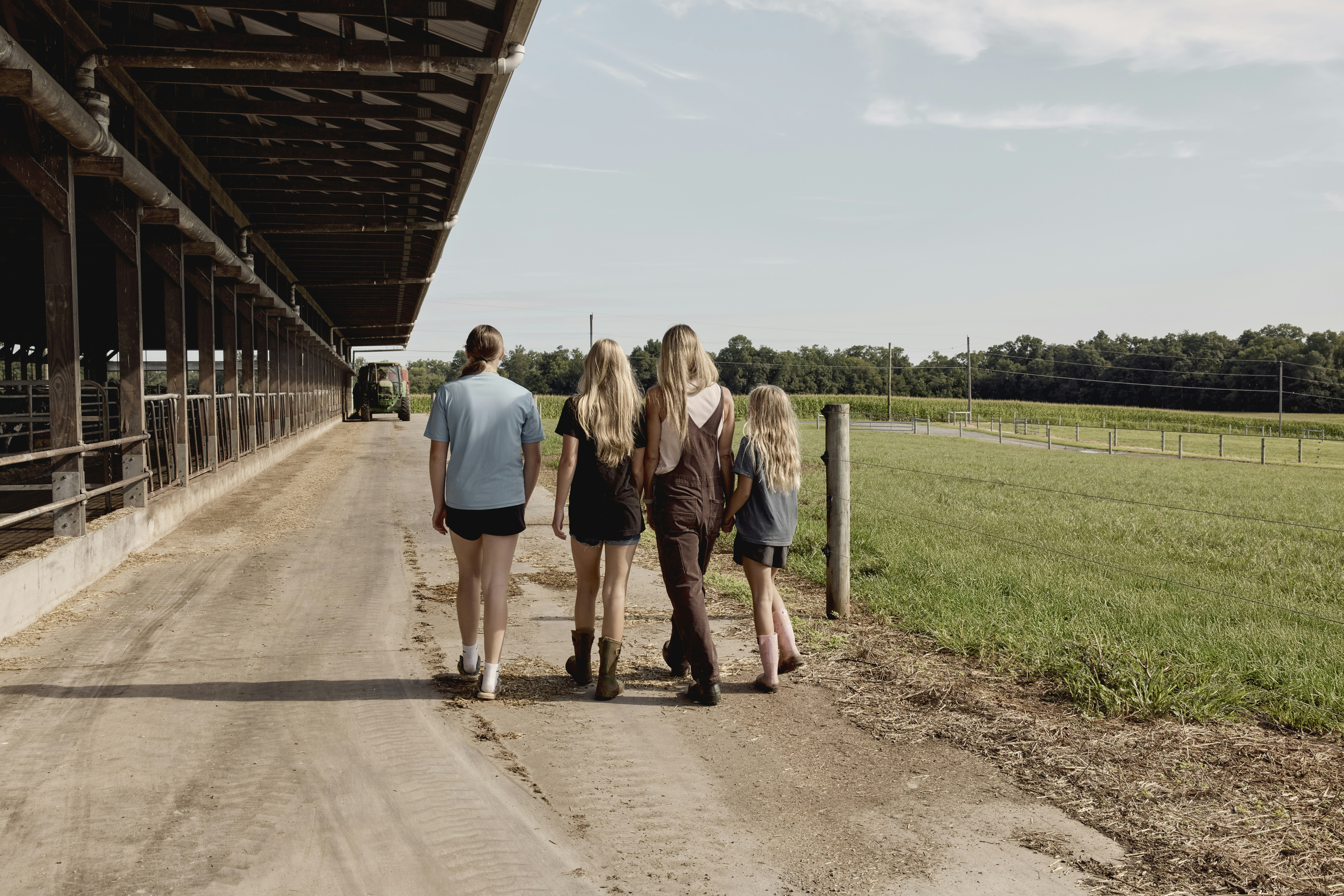 Group walking beside a dairy barn. Maryland, USA.