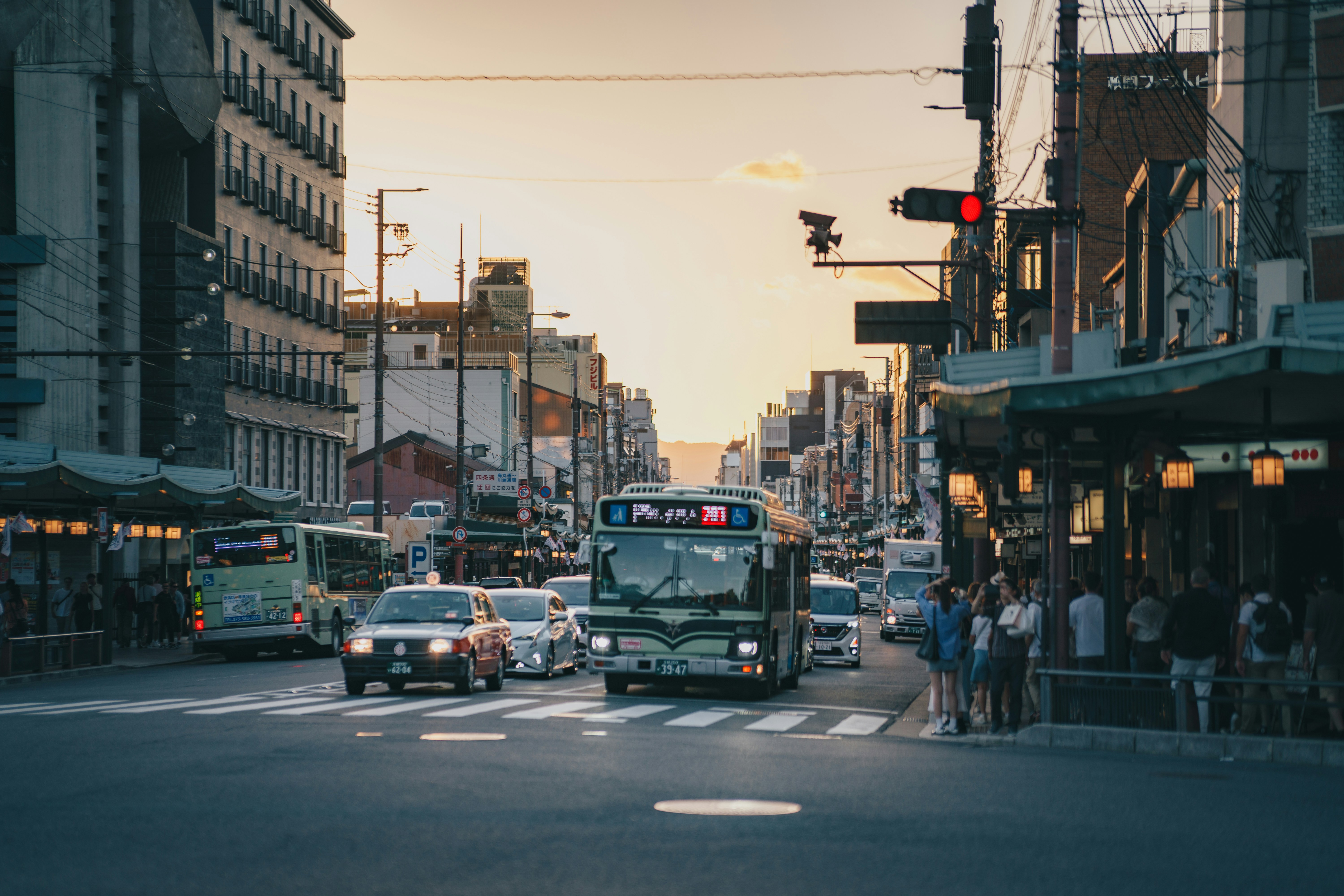 Bus et voitures dans une rue de la ville de Kyoto pendant l’heure dorée