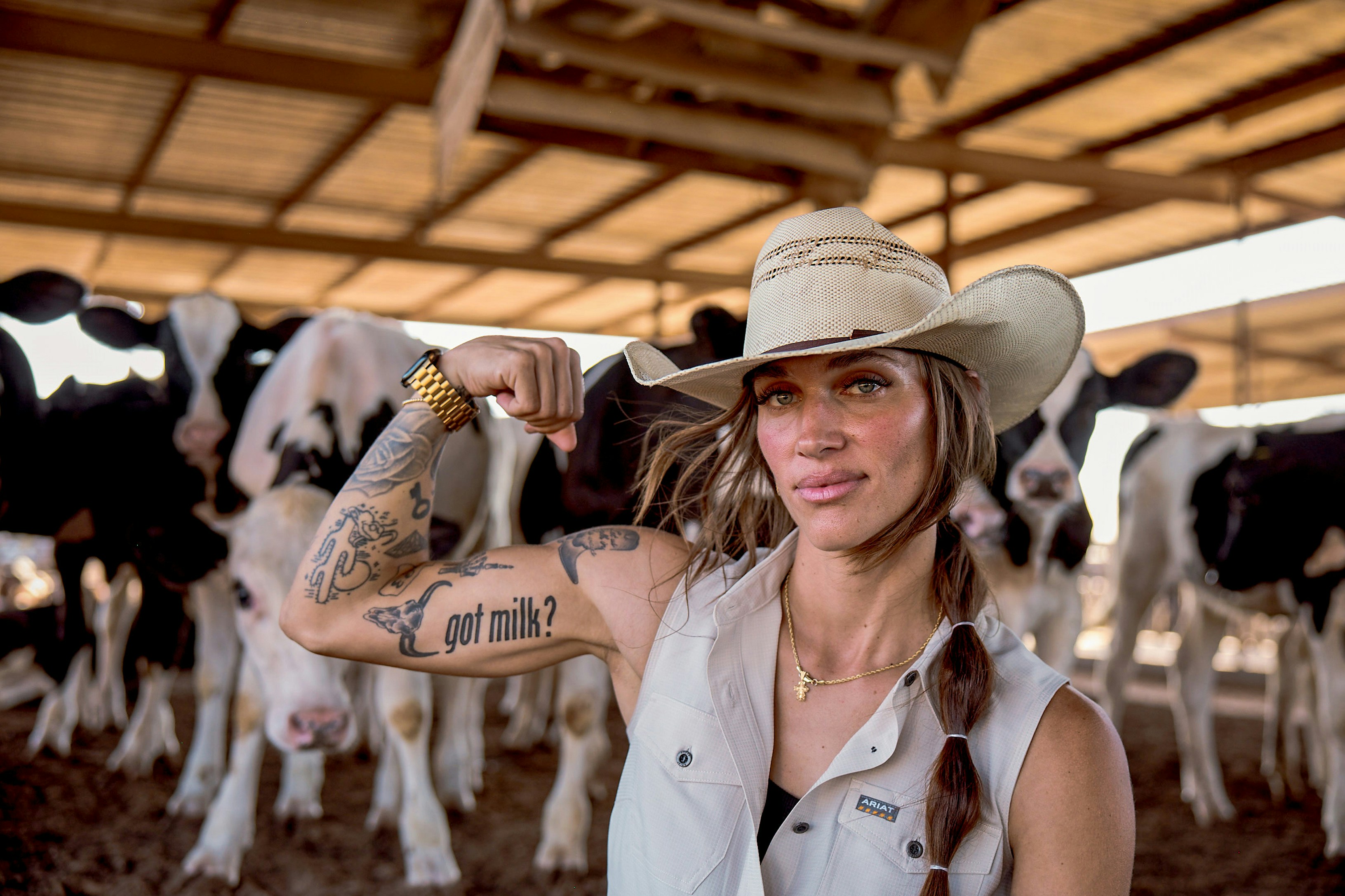 Woman in a cowboy hat beside dairy cows